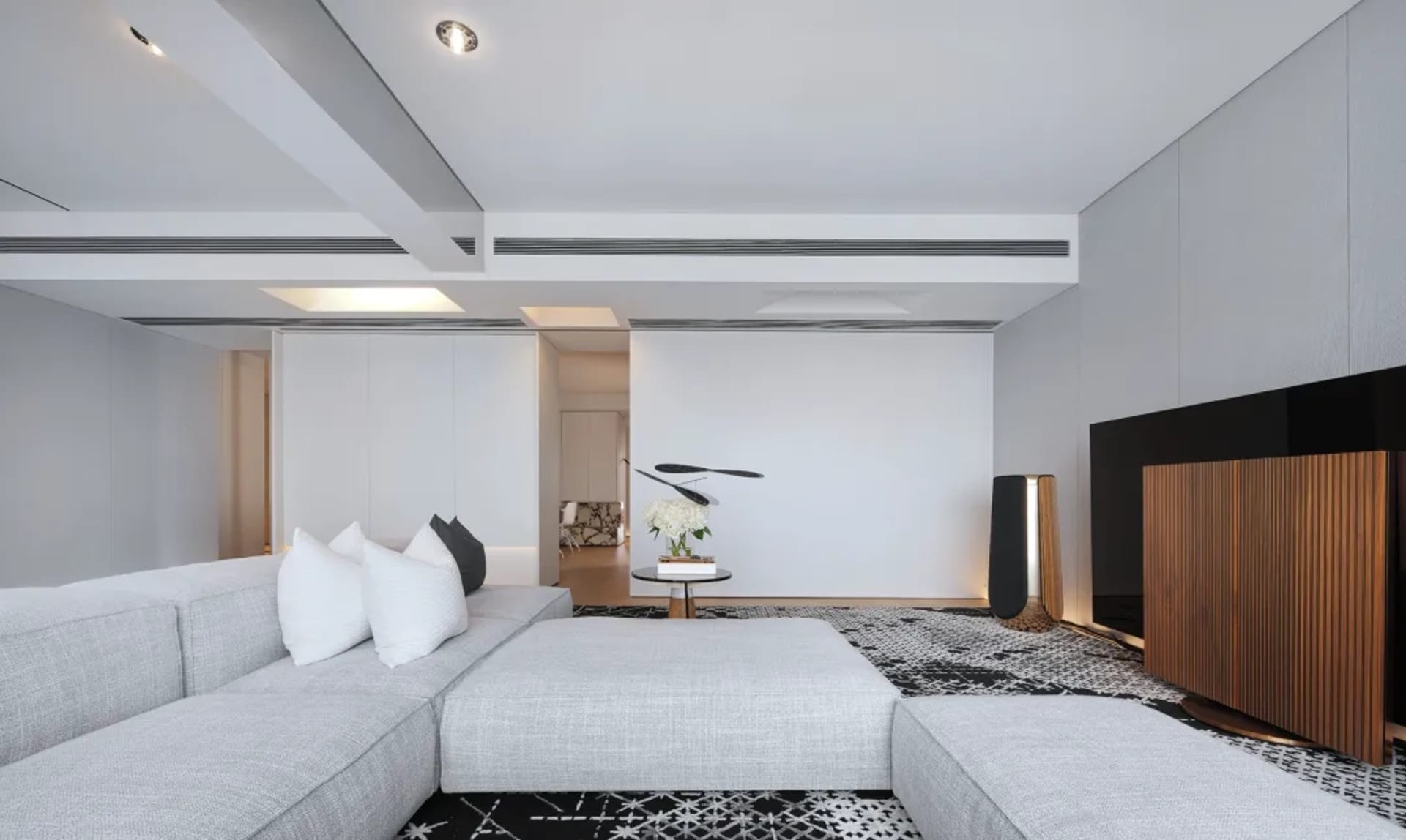 Modern living room with minimalist design, featuring a comfortable sectional couch, a sleek coffee table, and decorative acce