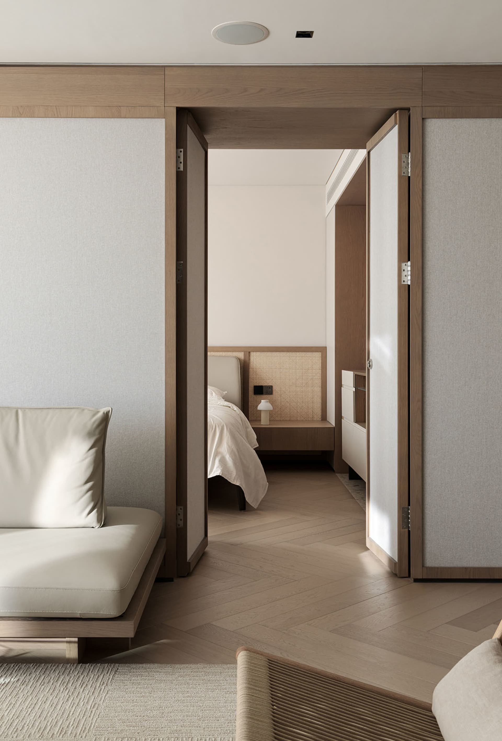 A modern minimalist bedroom featuring wood, textiles, and woven rattan elements.