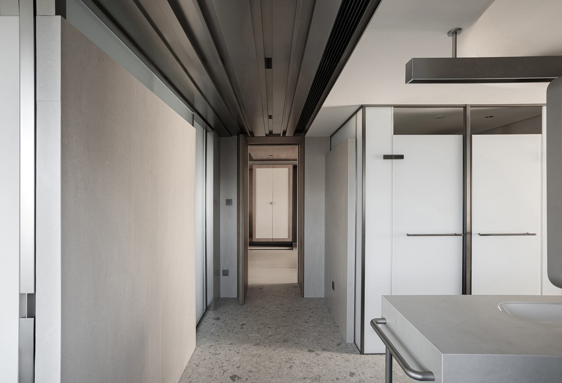 A modern, minimalist bathroom with concrete walls and floors, featuring sleek white fixtures and a clean, uncluttered design.