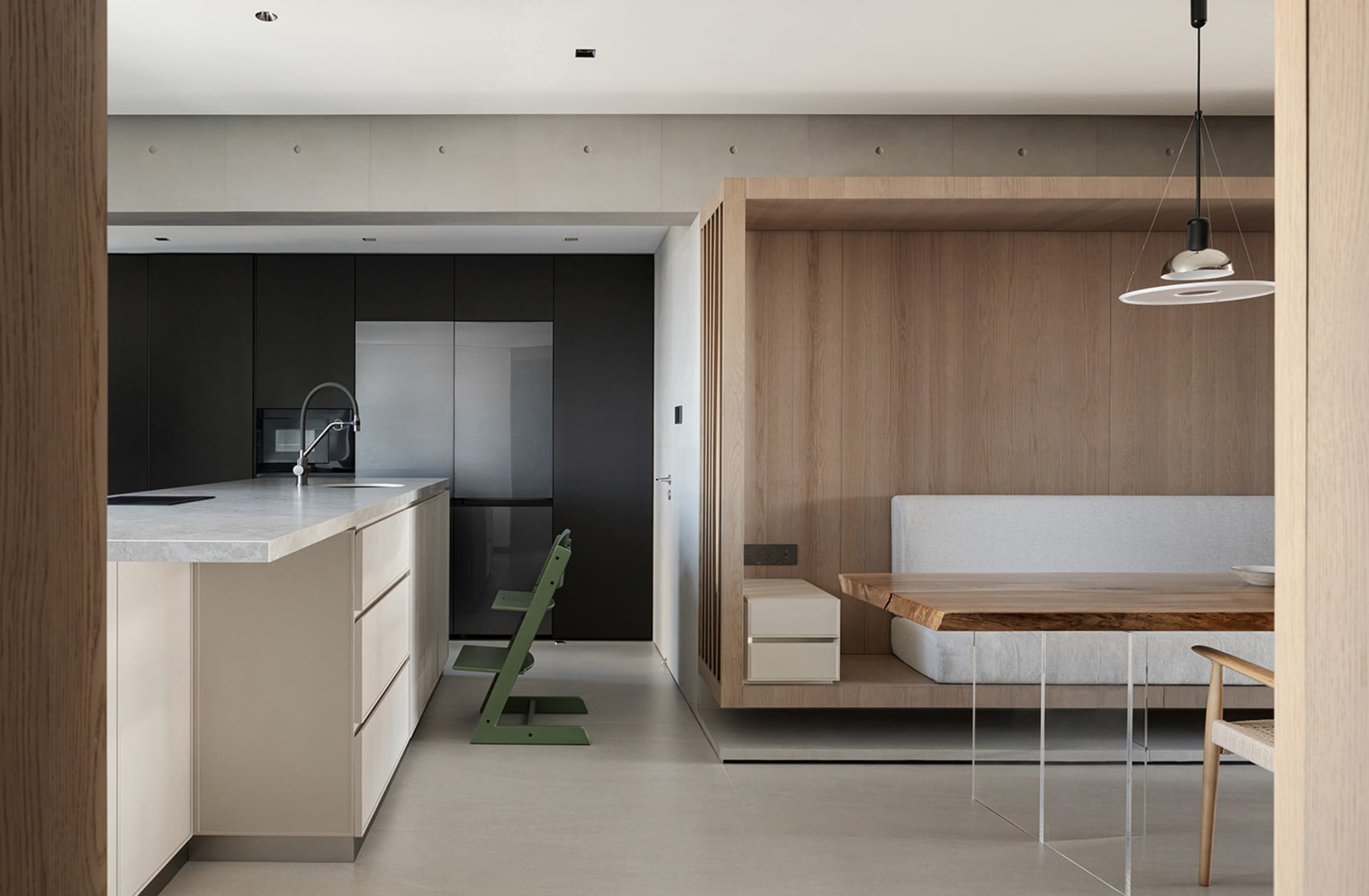 A modern minimalist kitchen featuring wooden elements, including a wooden dining table, chairs, and cabinetry, set against a