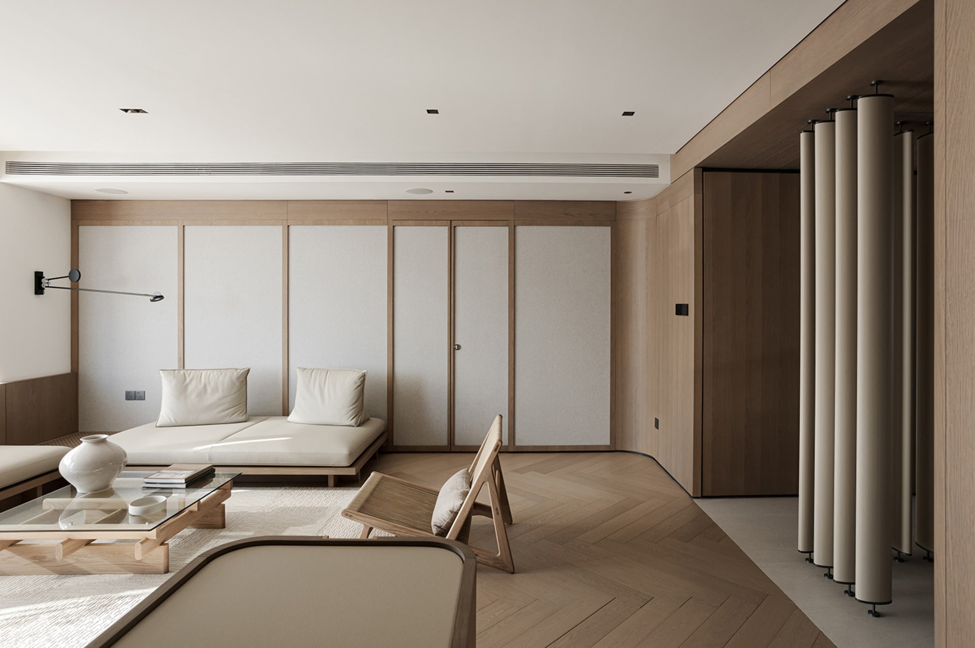 Modern minimalist living room with white furniture, wooden floor, and minimalist decor.