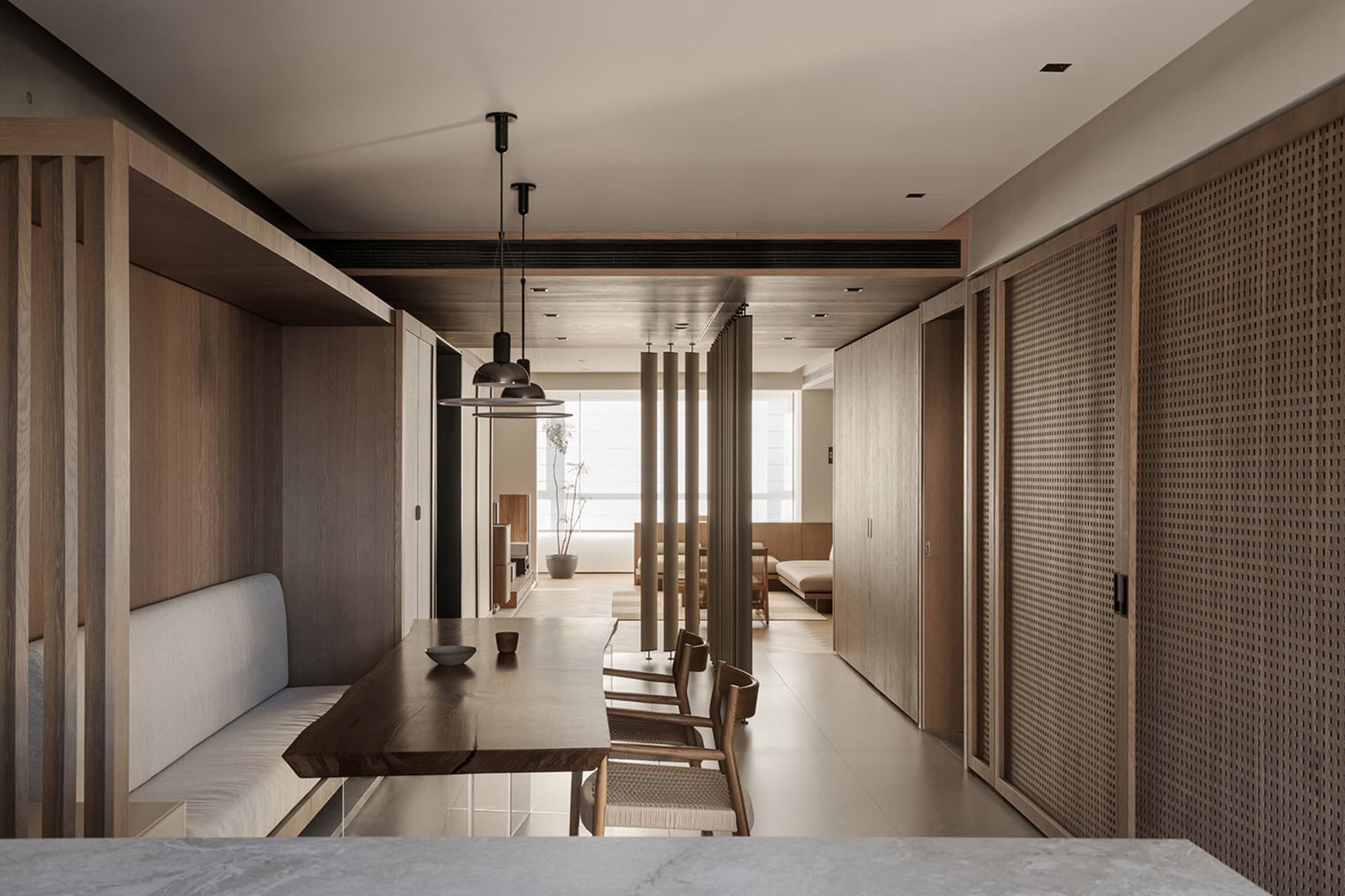Modern minimalist dining room with wooden furniture and white accents, featuring a live edge dining table and built-in seatin