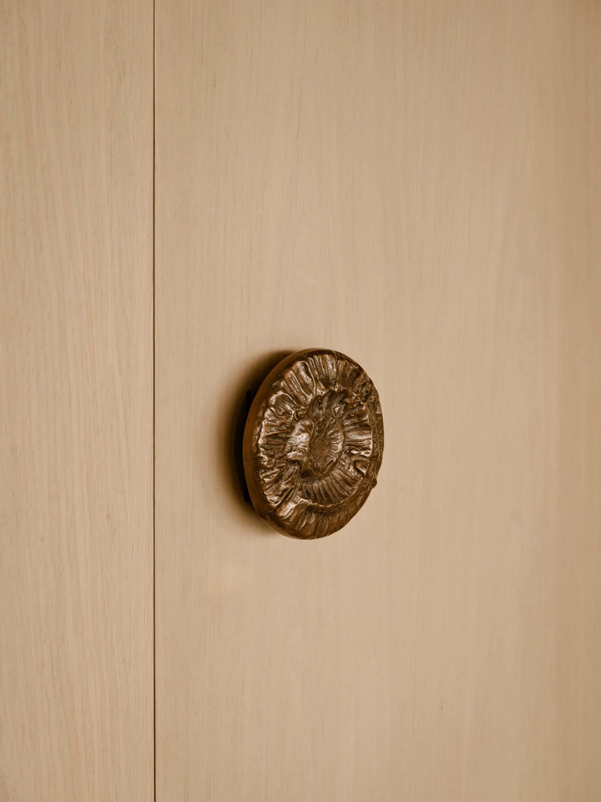 A modern minimalist brown door handle with a textured design