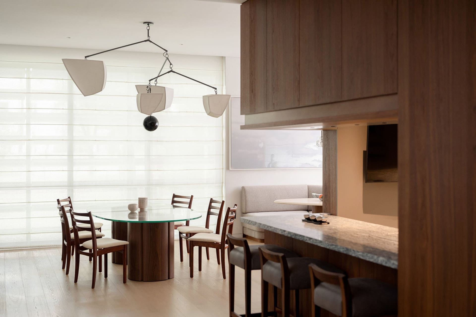 Modern living and dining space featuring wooden furniture and a glass table.