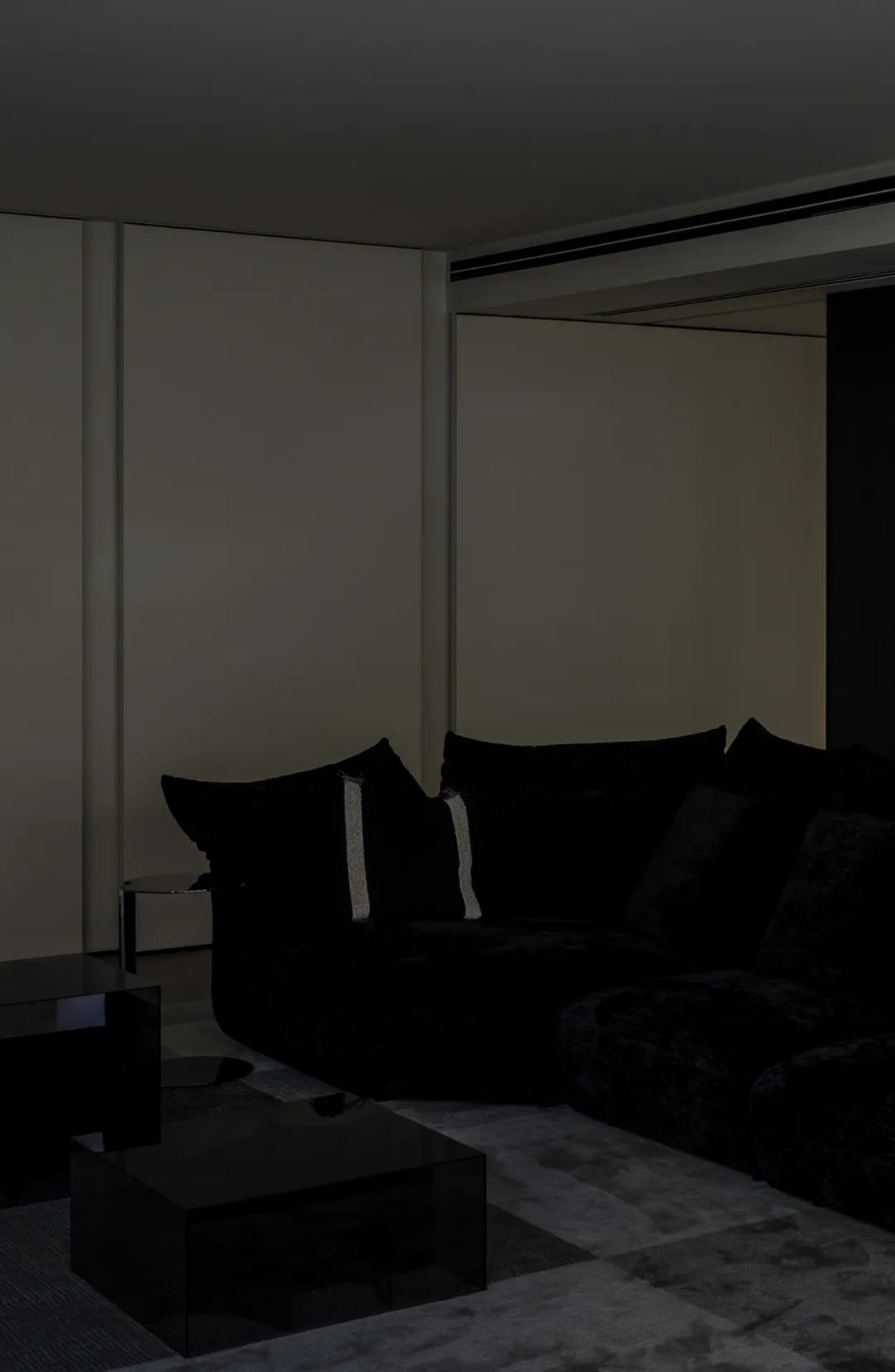 Modern living room with a black fabric sofa and minimalist decor.
