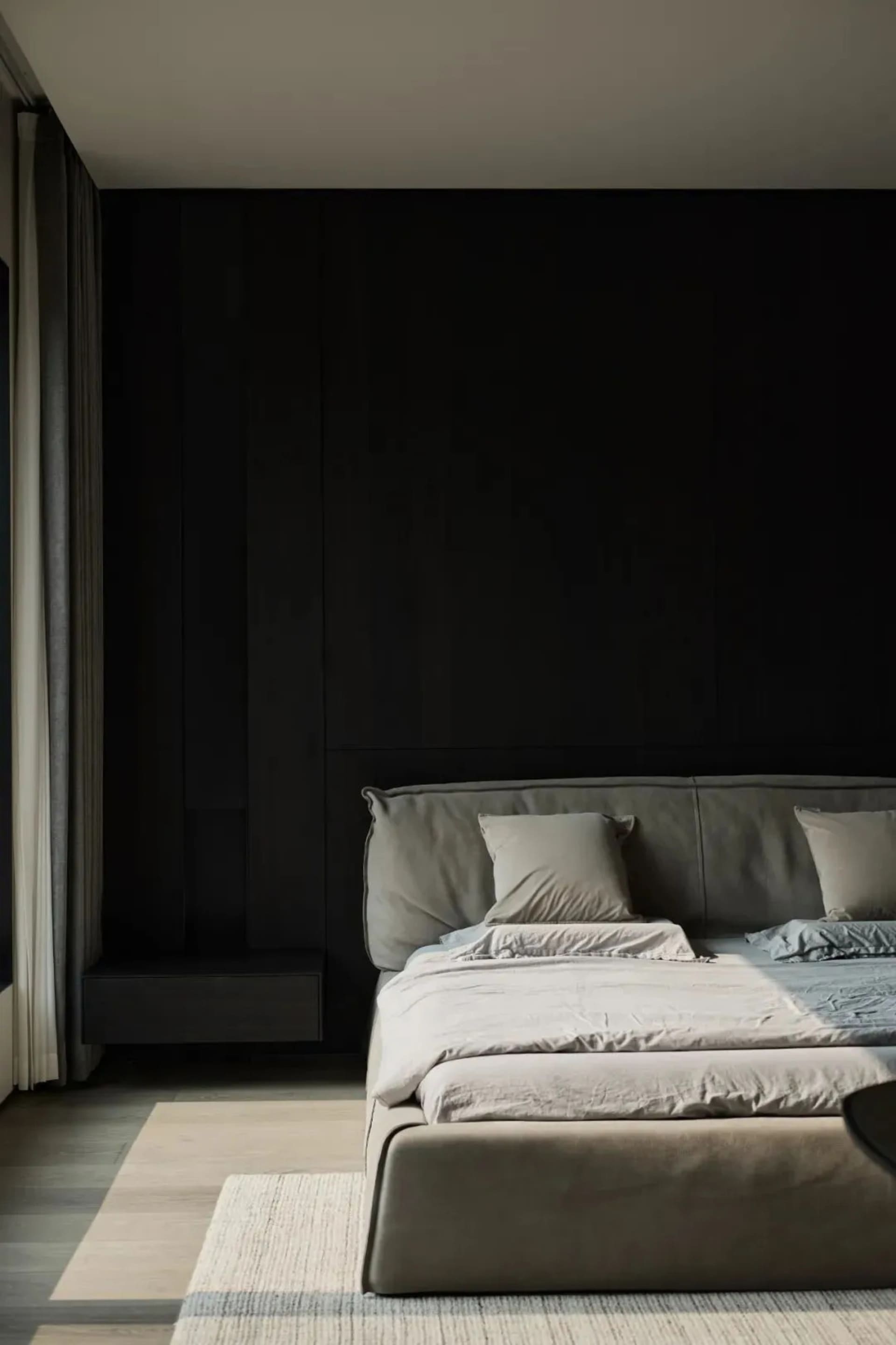 A modern minimalist bedroom with textured wooden walls and fabric bedding.