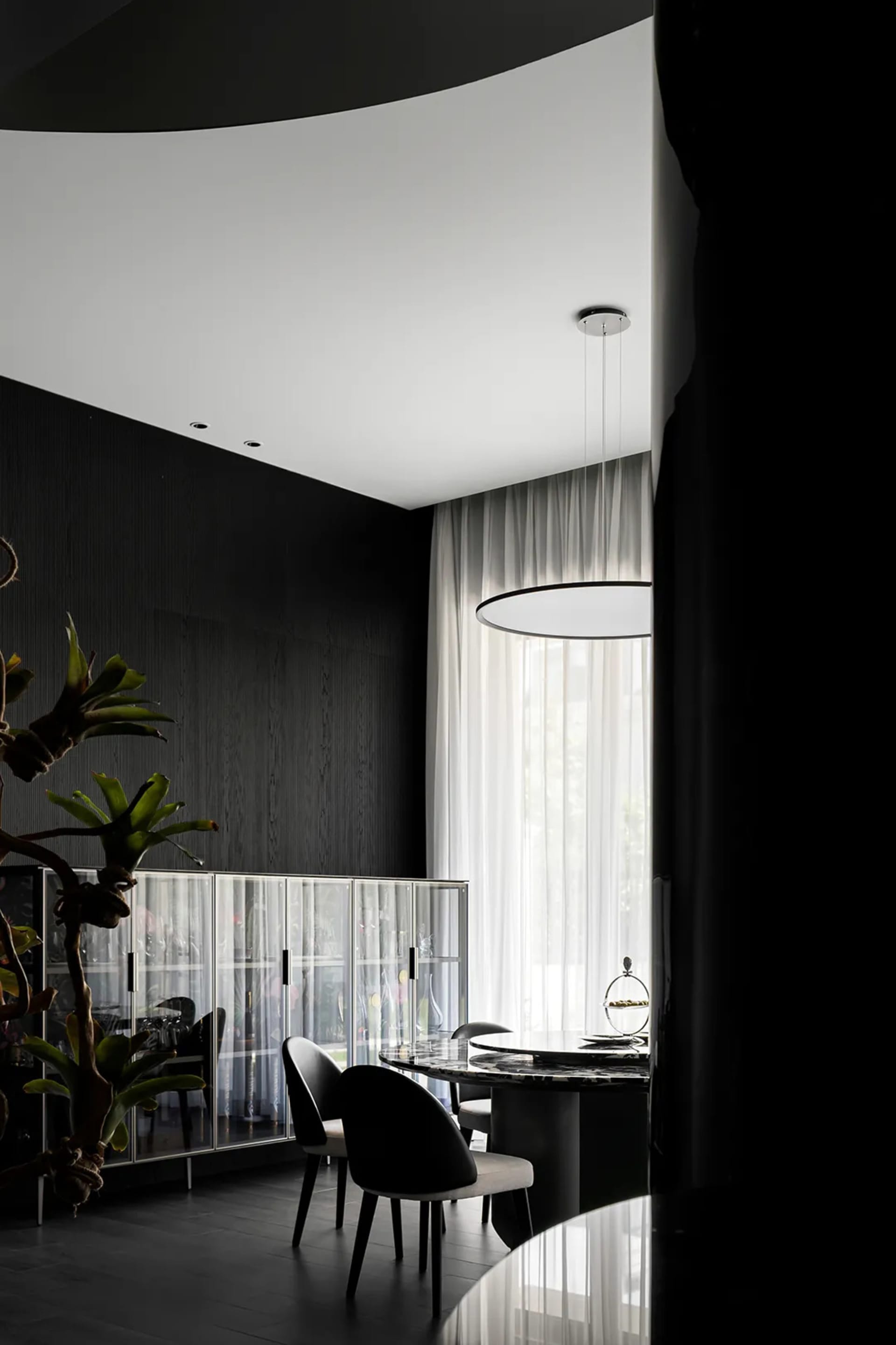 Modern minimalist dining room featuring glass, marble, and metal elements.