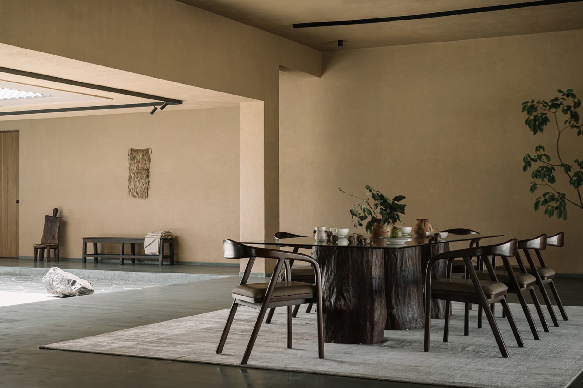 Modern dining room with wooden table and chairs, minimalist decor, and natural light.