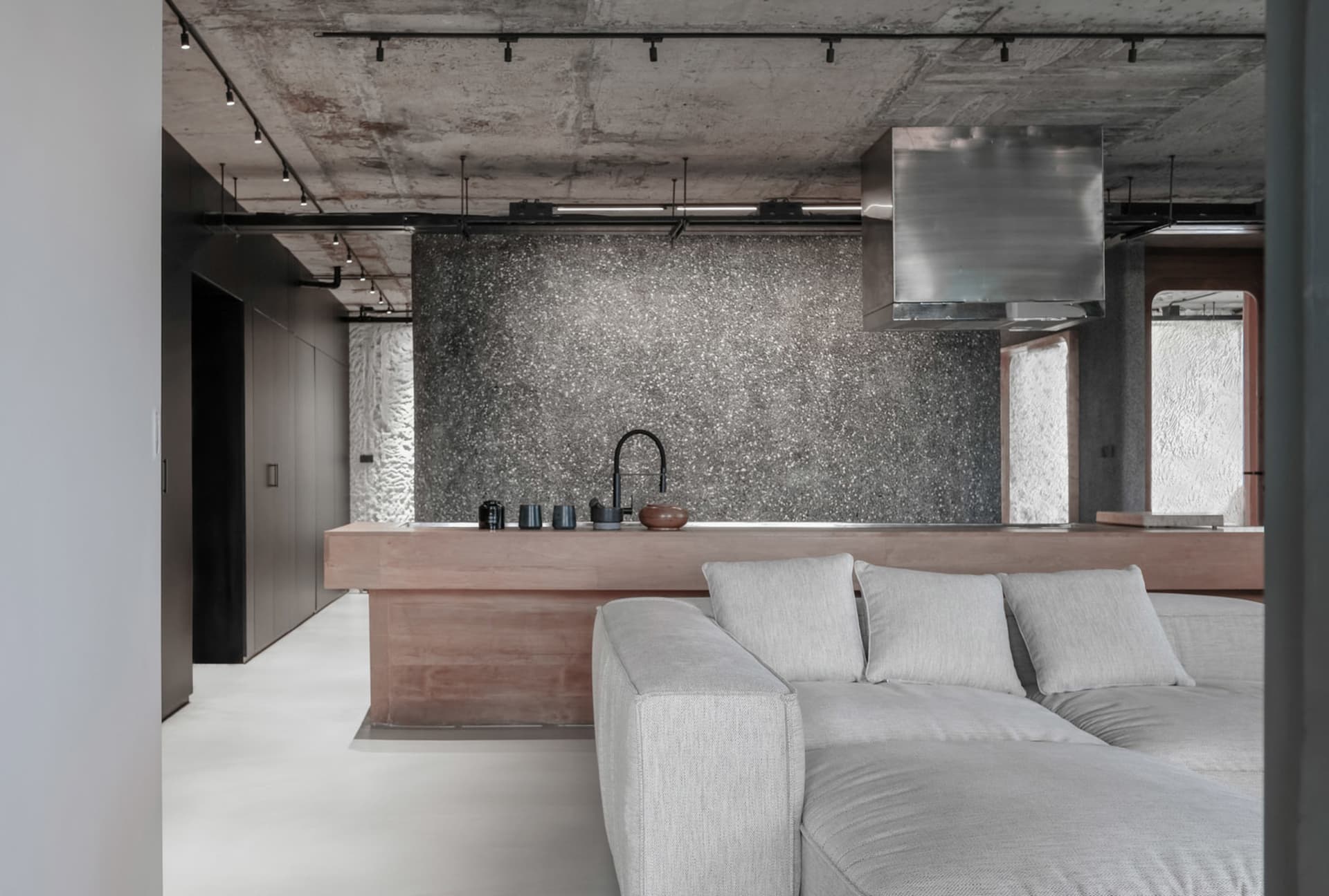 Modern industrial-style kitchen featuring exposed concrete walls and a minimalist design.