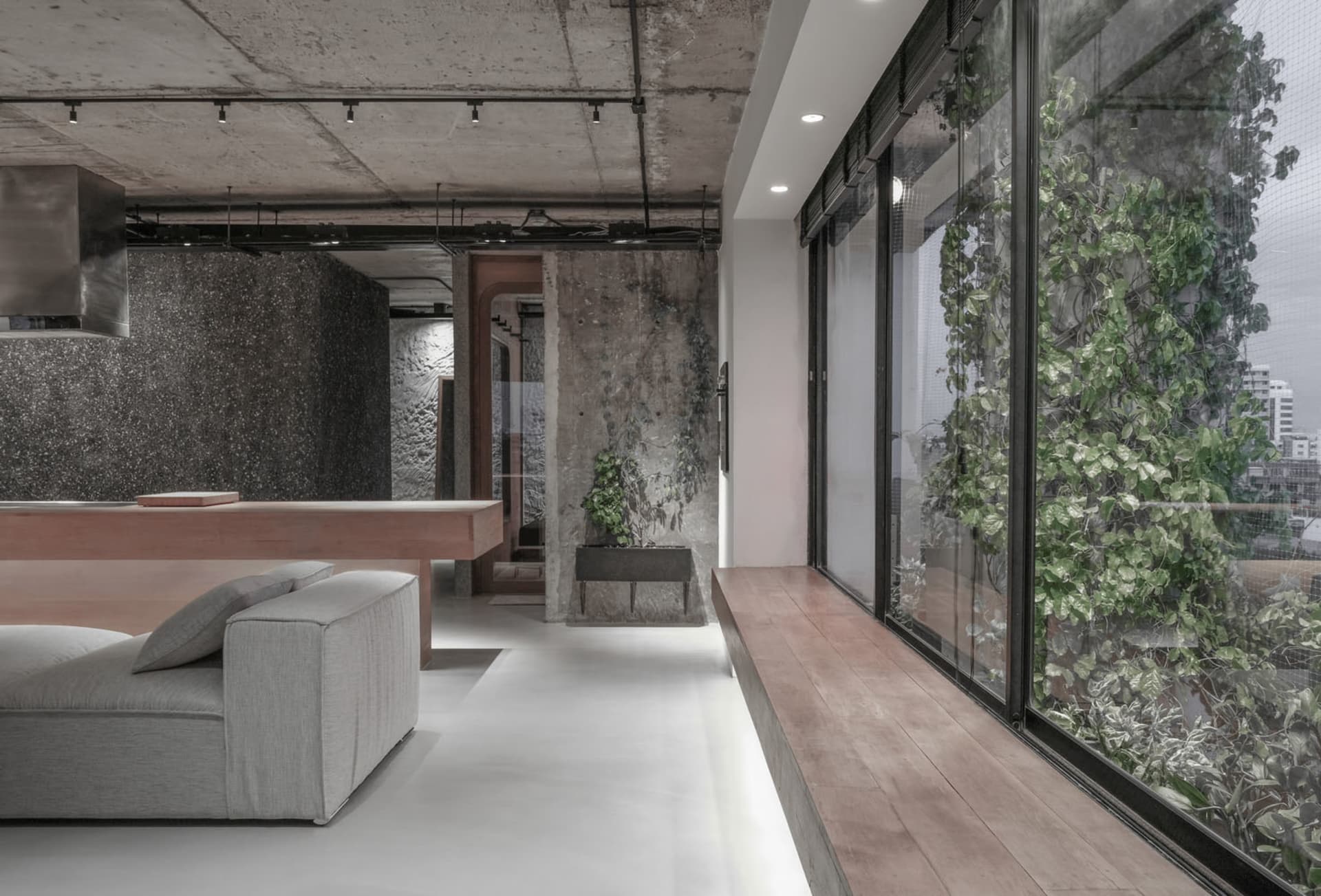 A modern-industrial living room with greenery and concrete wood materials, featuring a contemporary interior design with mini