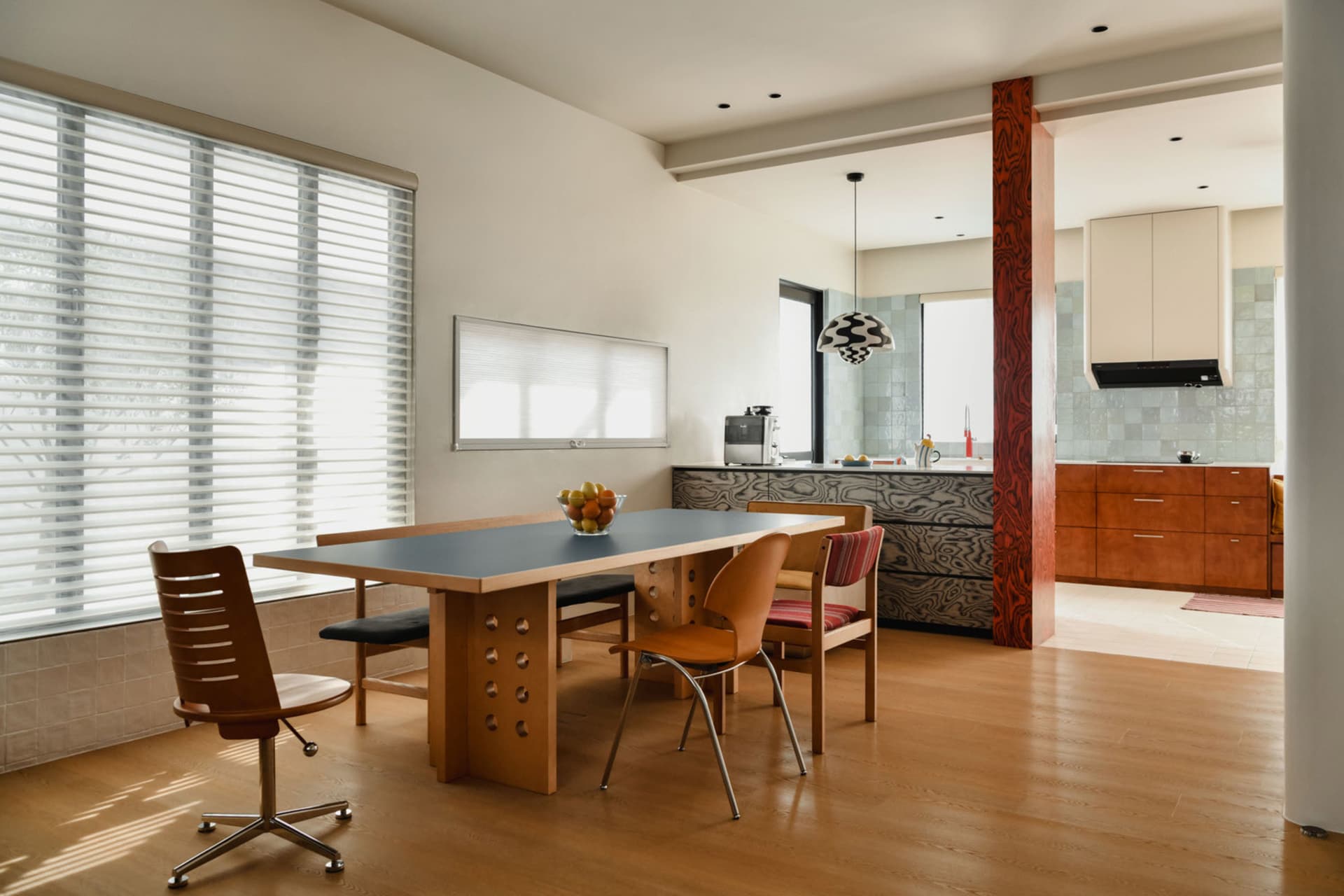 Modern residential kitchen featuring a concrete countertop and wooden furniture.