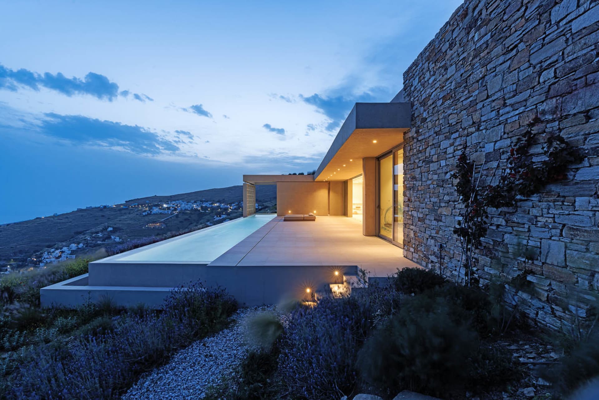 Modern residential pool deck with stone and concrete materials.