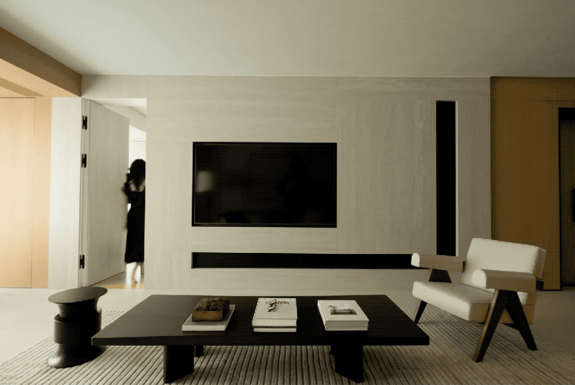 A modern living room with a black and white color scheme, featuring a flat-screen TV mounted on a wall, a black coffee table,