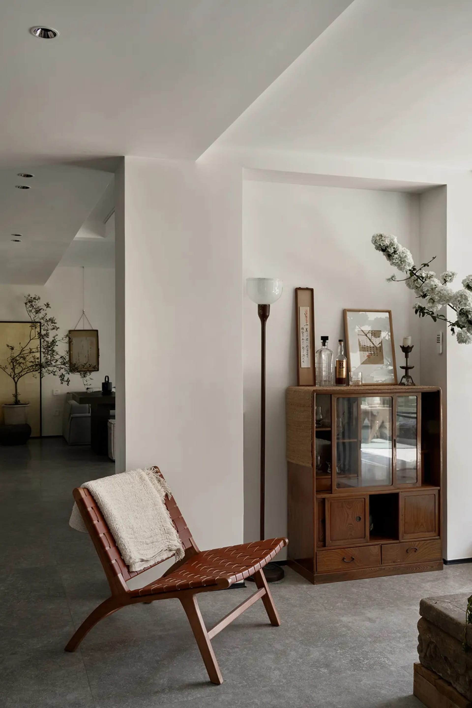 A modern living room featuring a wood armchair with a concrete floor, providing a comfortable and stylish lounge area.