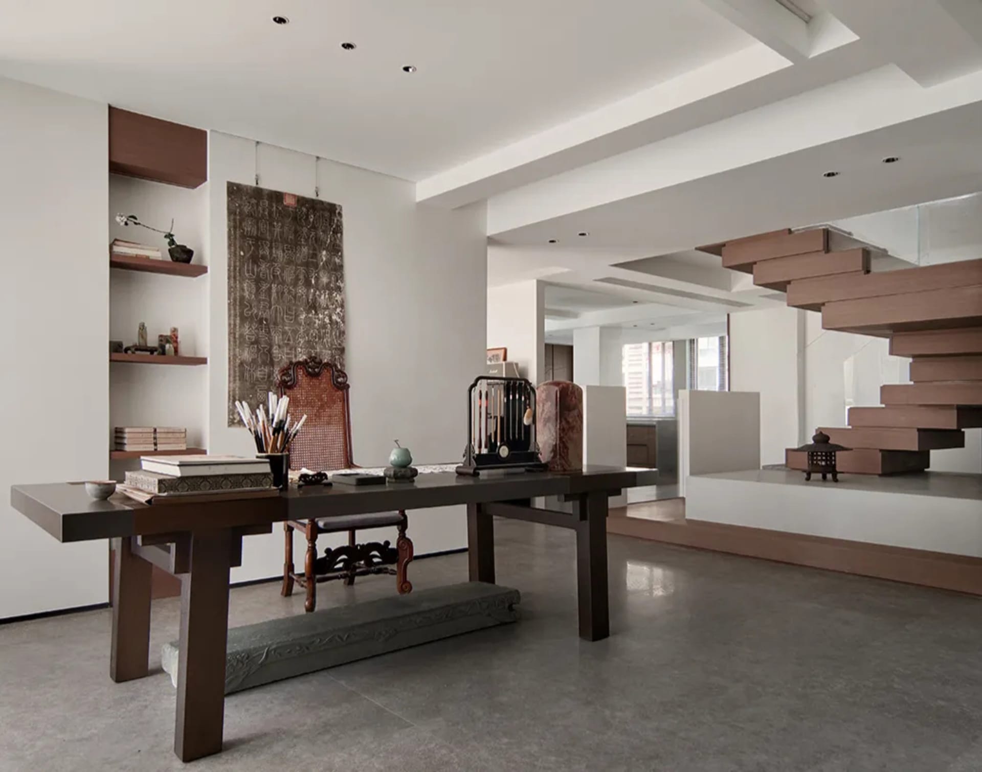 A modernist living room with a concrete staircase and minimalist decor.