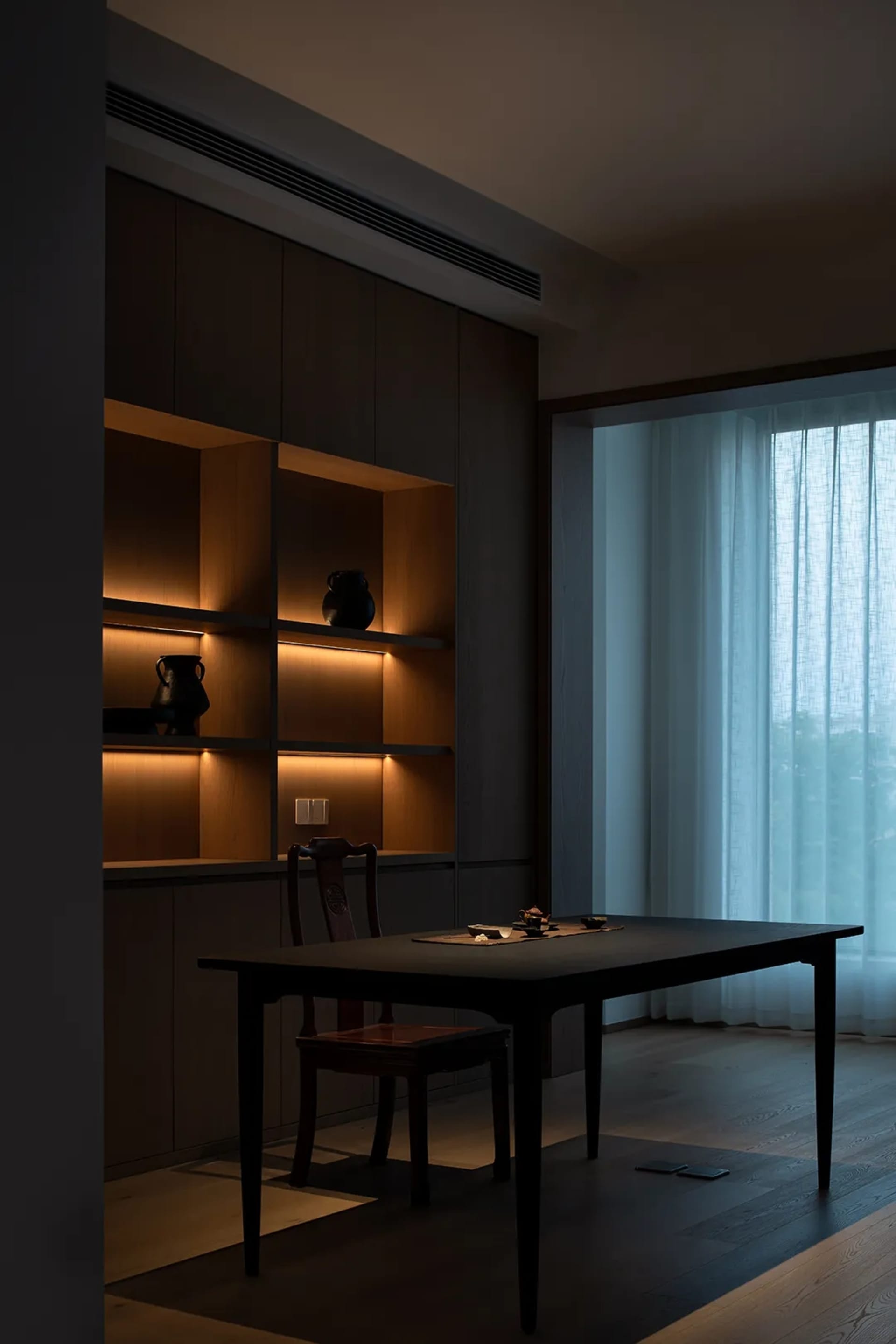 現代餐廳內設有木質層架,以及深色木質餐桌與茶具組。