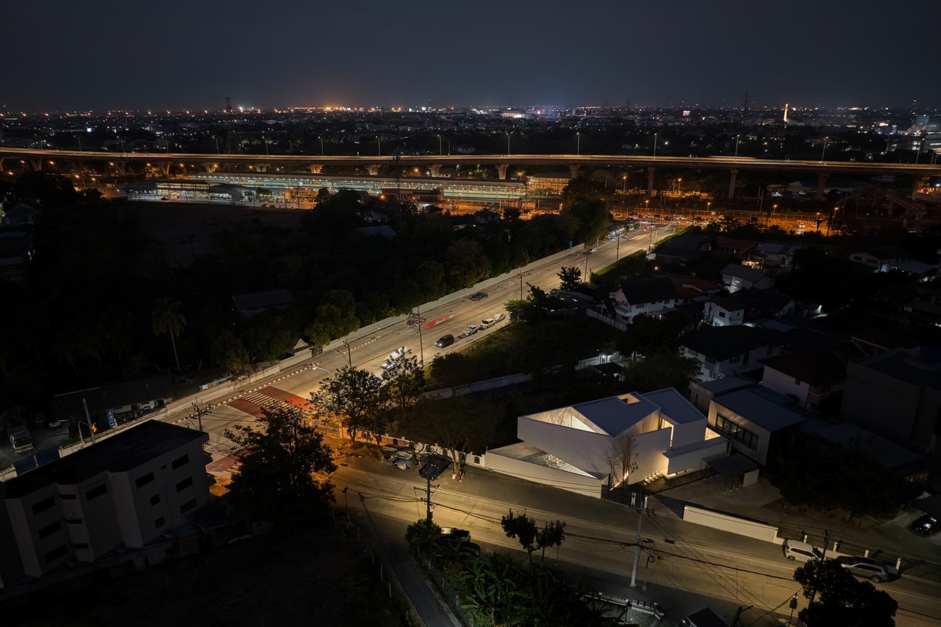 夜間俯瞰城市街道，車輛與建築物燈光通明。