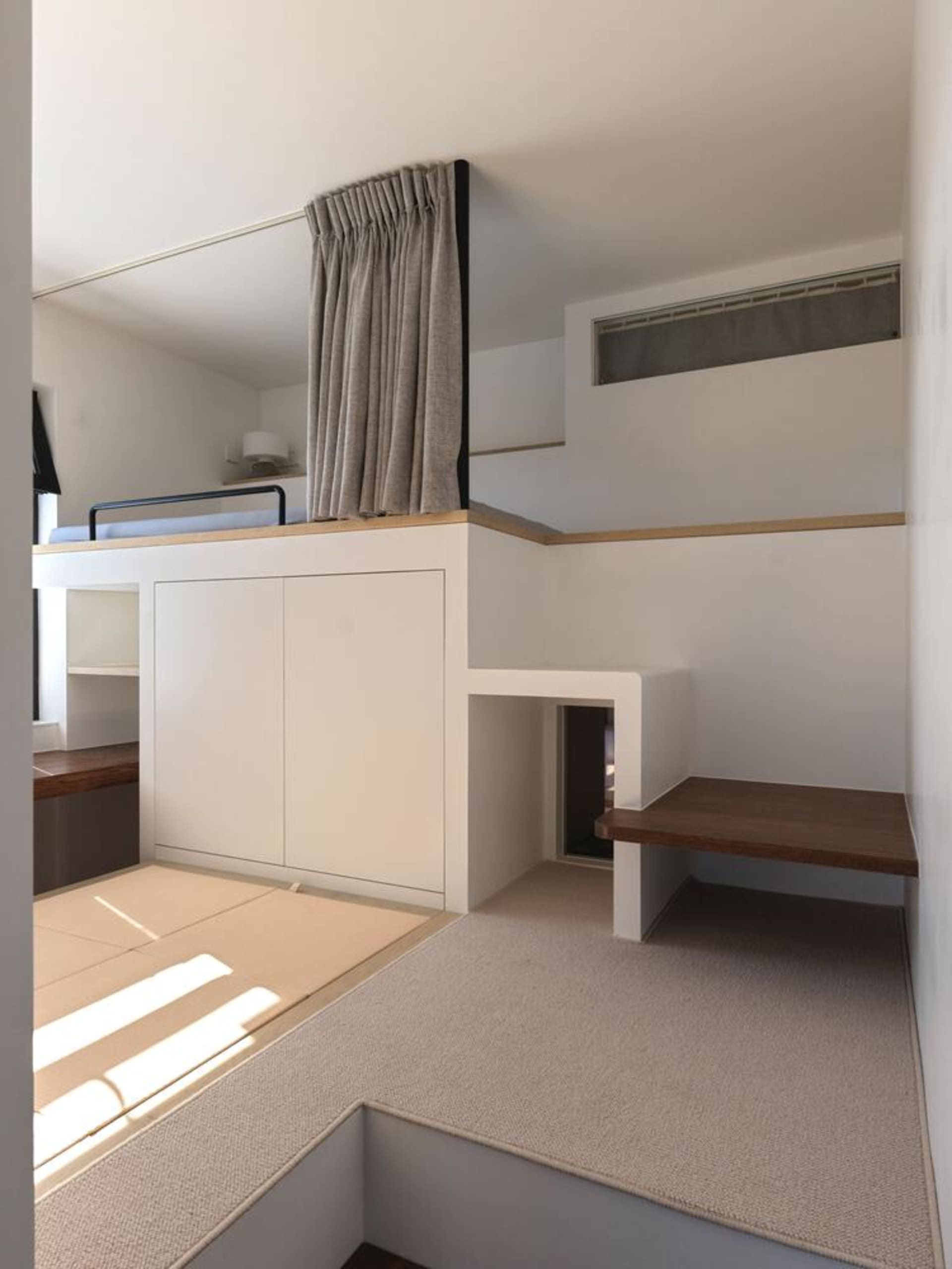 A modern apartment with concrete platforms and wooden stairs.