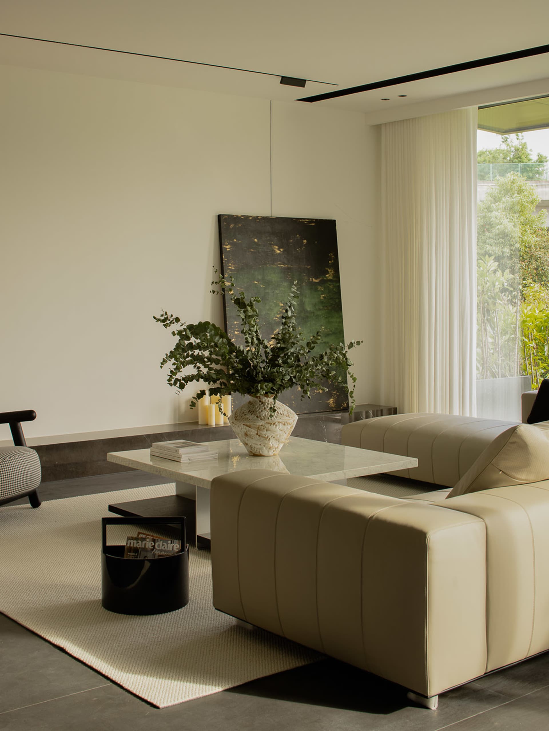 A modern interior living room with contemporary furniture, including a leather couch, marble coffee table, and decorative pla