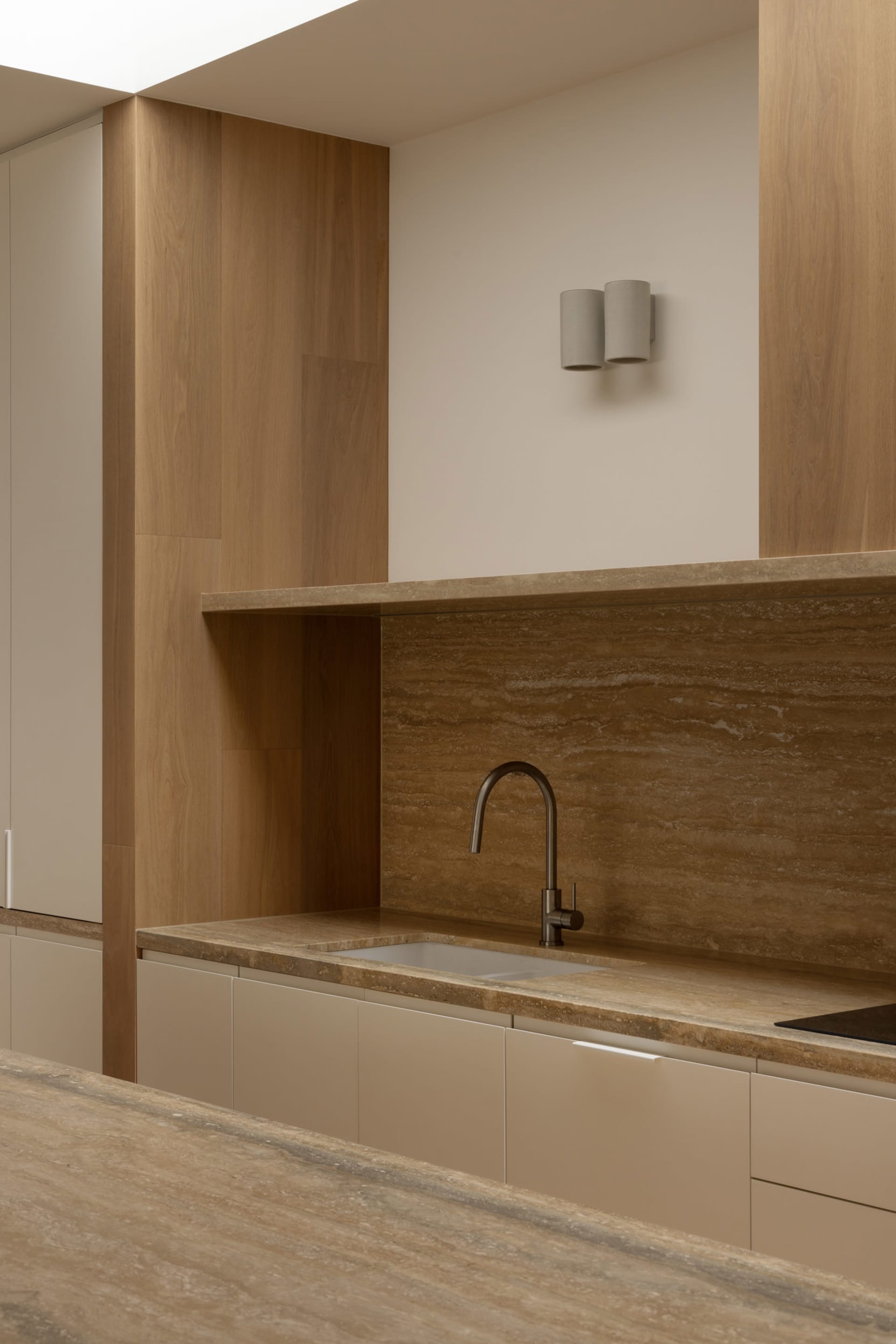 Modern minimalist kitchen featuring sleek wooden cabinets and marble countertops and backsplash