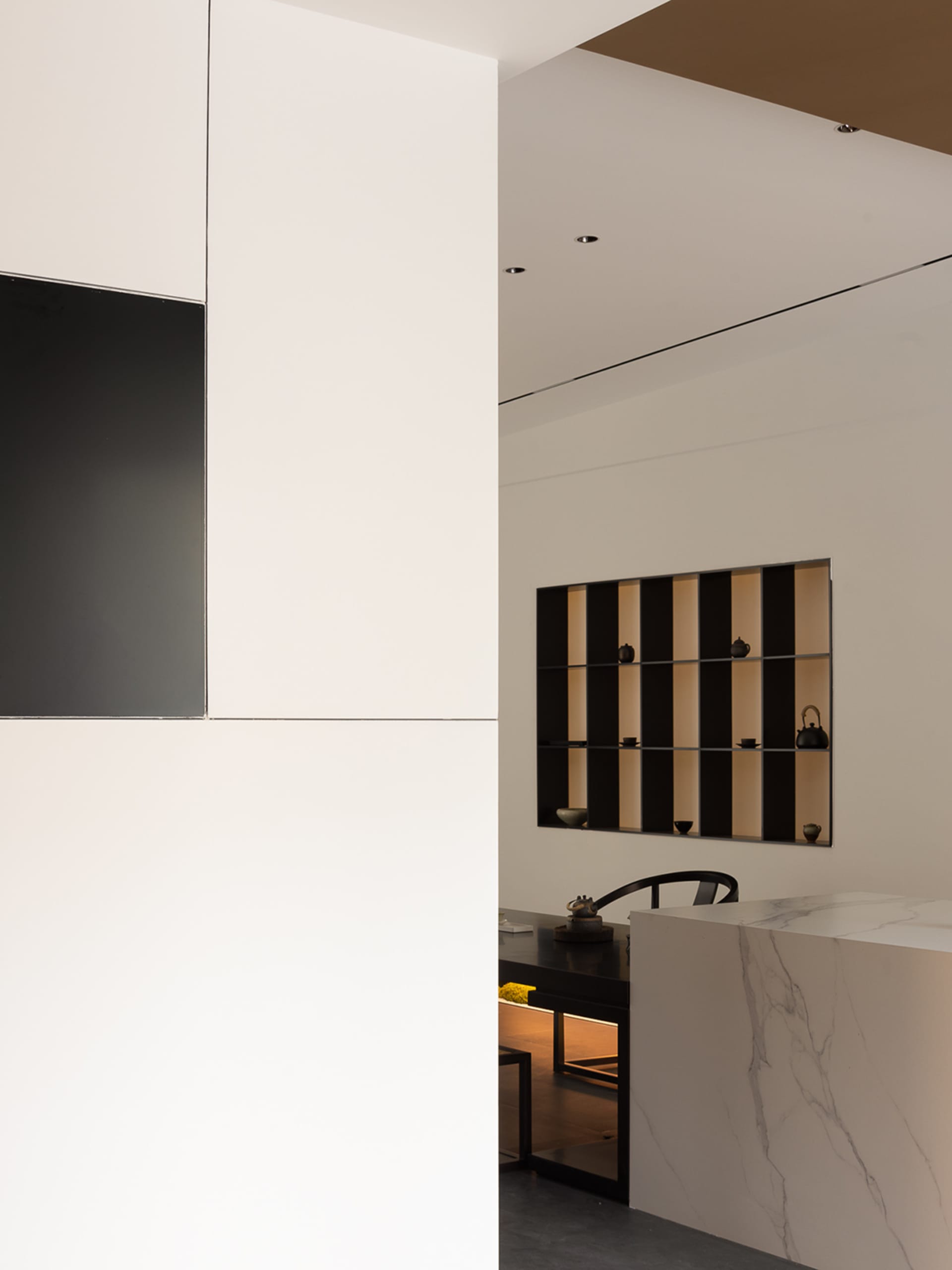 Modern tea room with minimalist design, featuring white marble countertops and black accents.