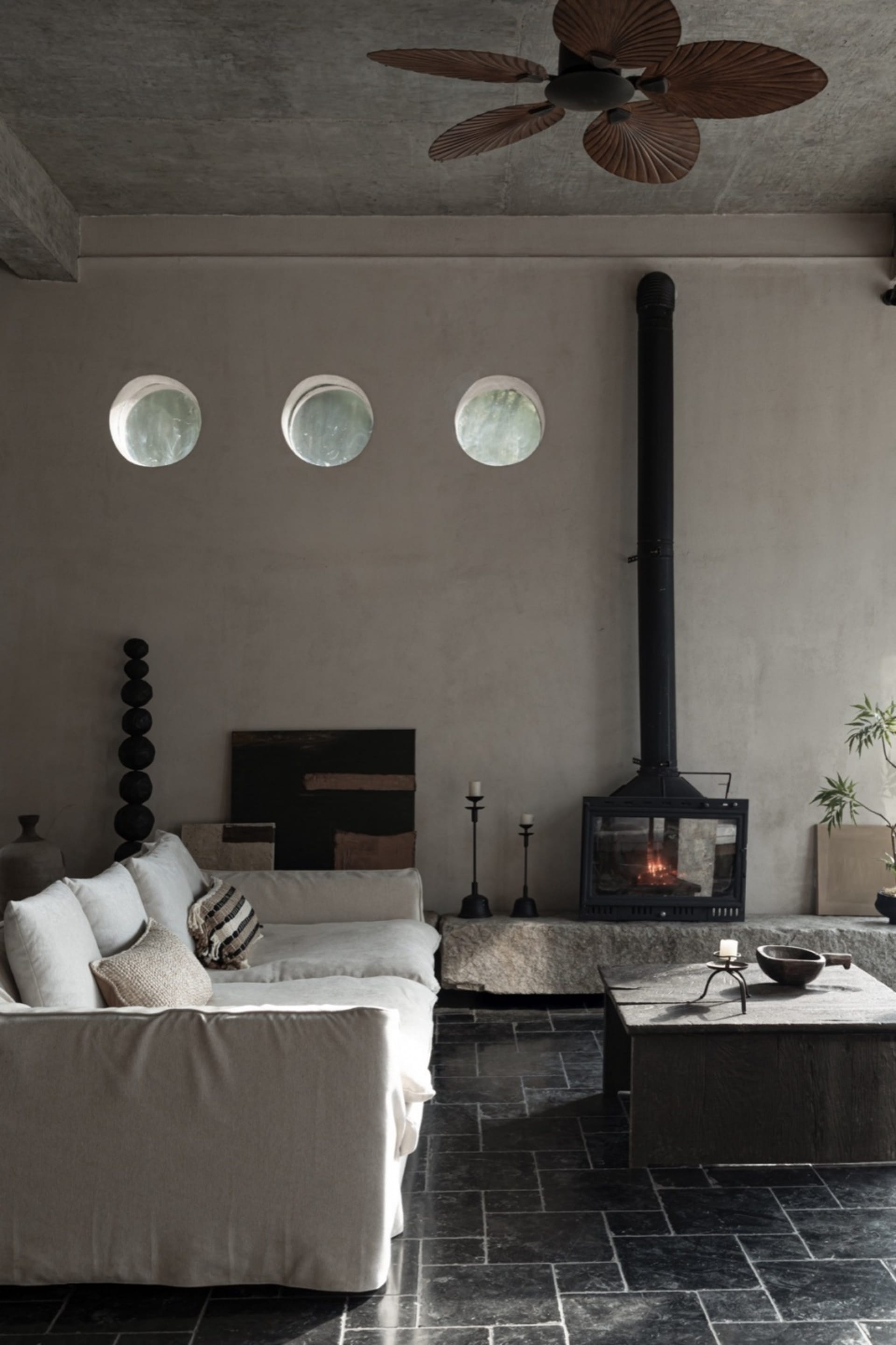 A cozy industrial living room with a concrete fireplace, wooden coffee table, and minimalist decor.