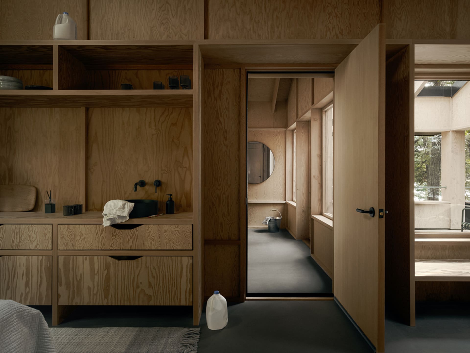 Modern, minimalist residential interior with wooden walls, shelves, and floor.
