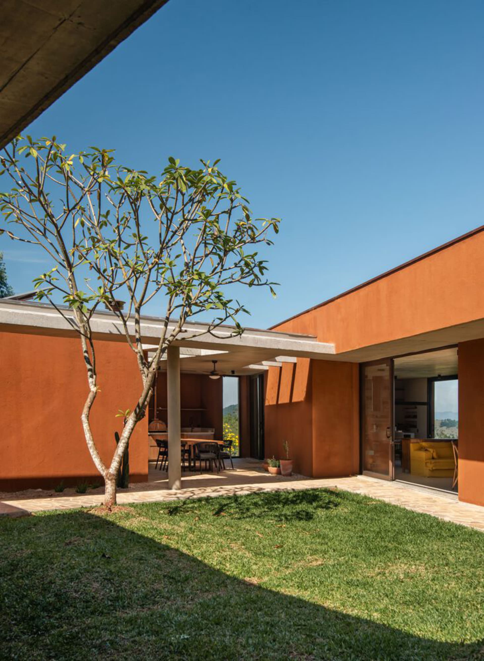Modern residential exterior with concrete walls and a tree.
