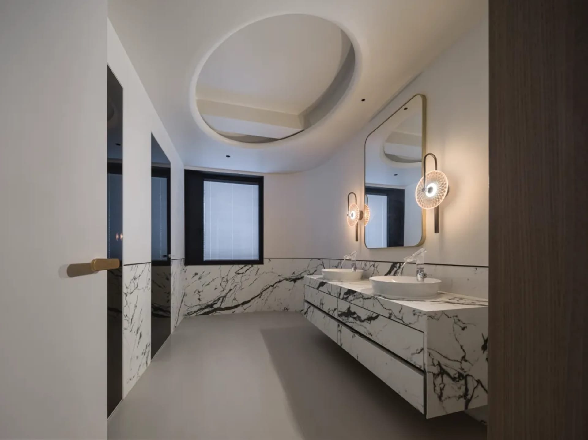 Modern bathroom with marble accents, white marble countertops, and a sink with a floating vanity.
