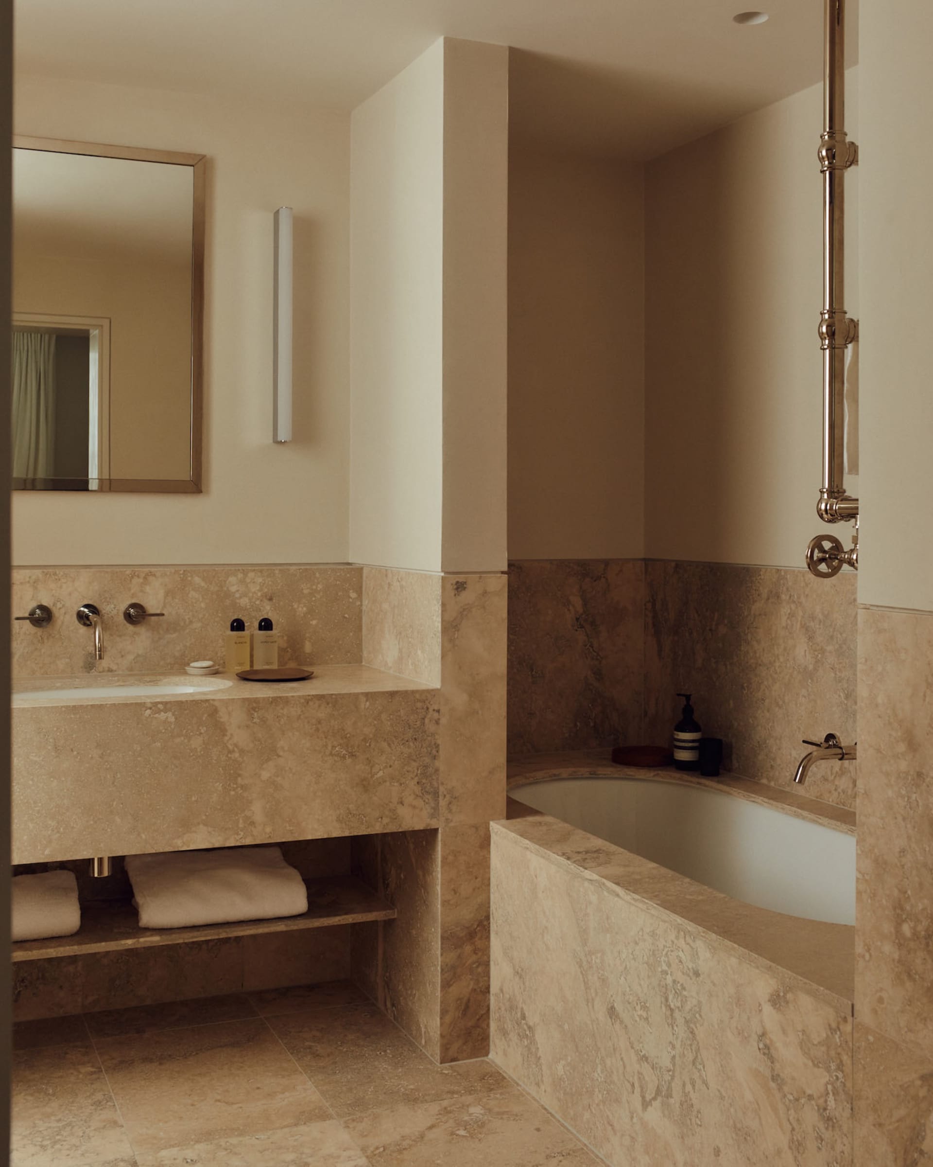 Modern minimalist bathroom featuring marble tiles and fixtures.