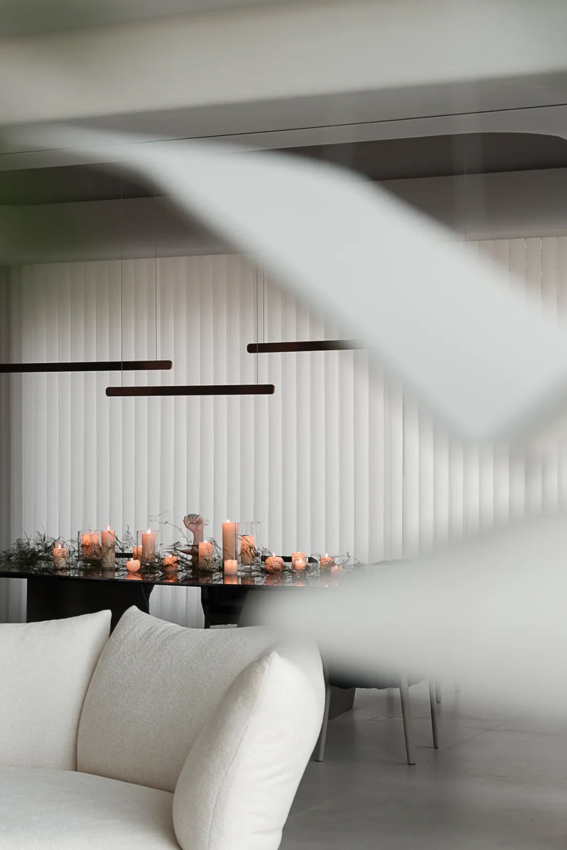 A minimalist dining room adorned with candles and fabric elements.