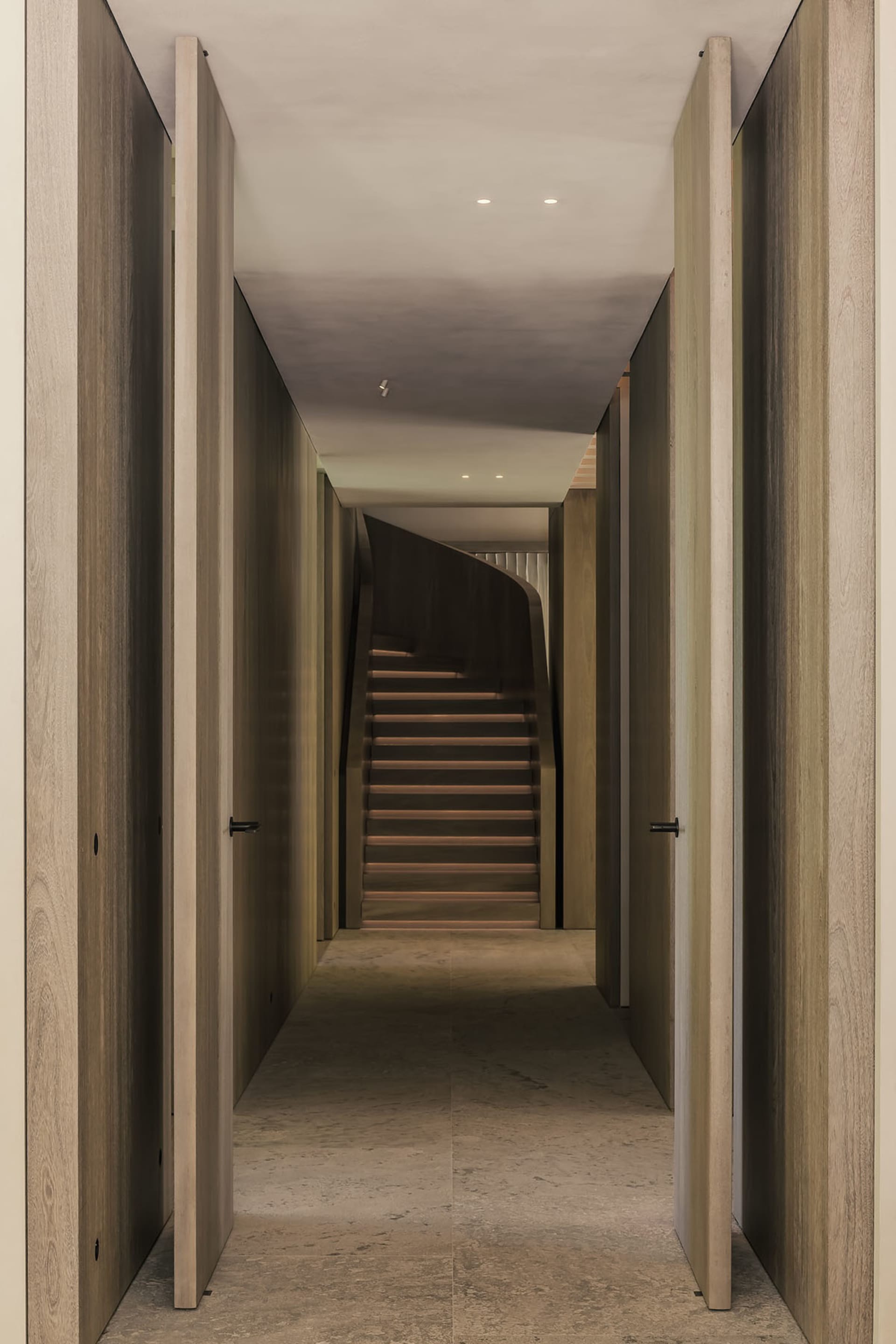 A modern interior space with a wooden staircase and walls.