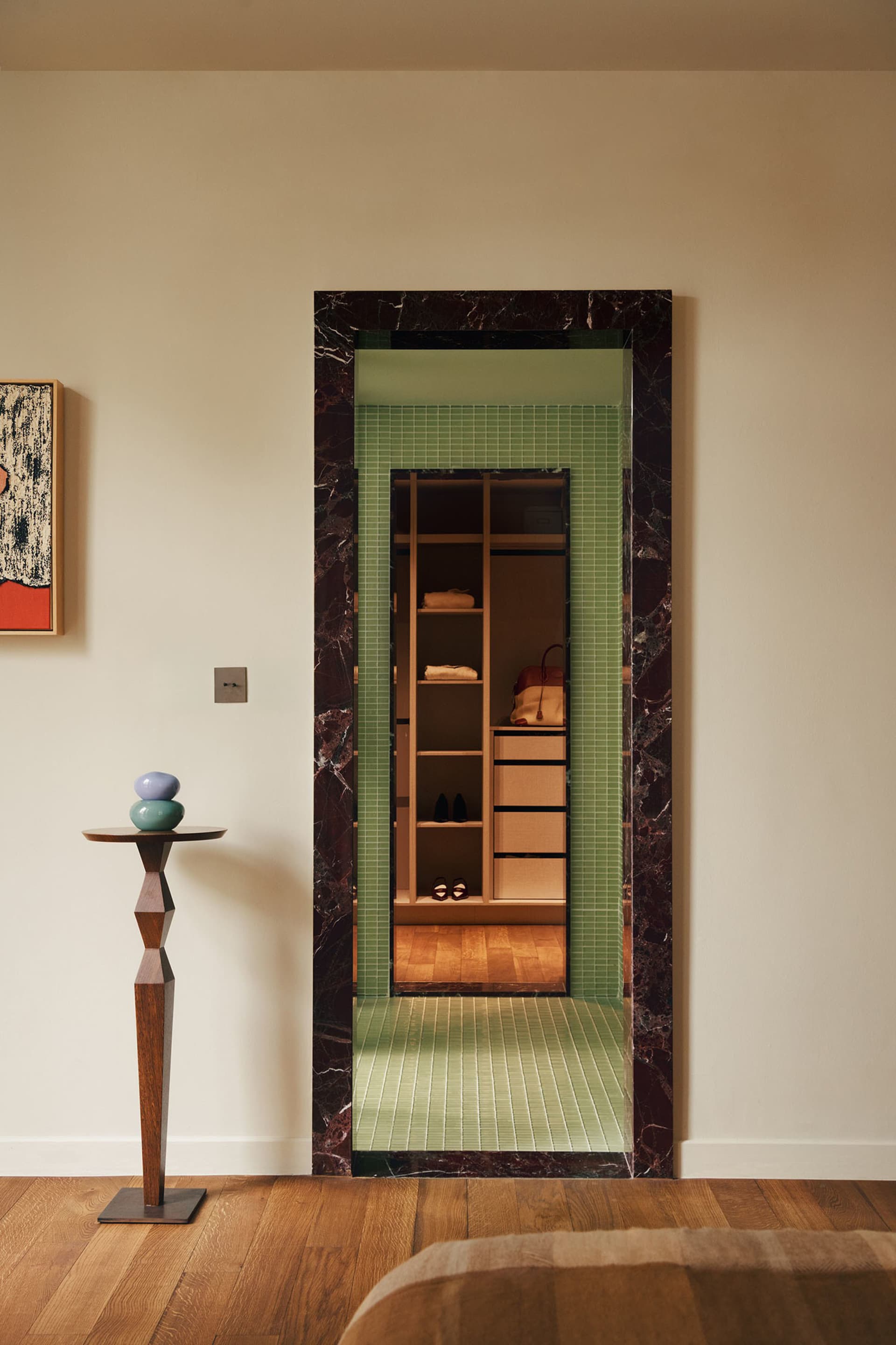Modern closet display with marble frame and green tile flooring