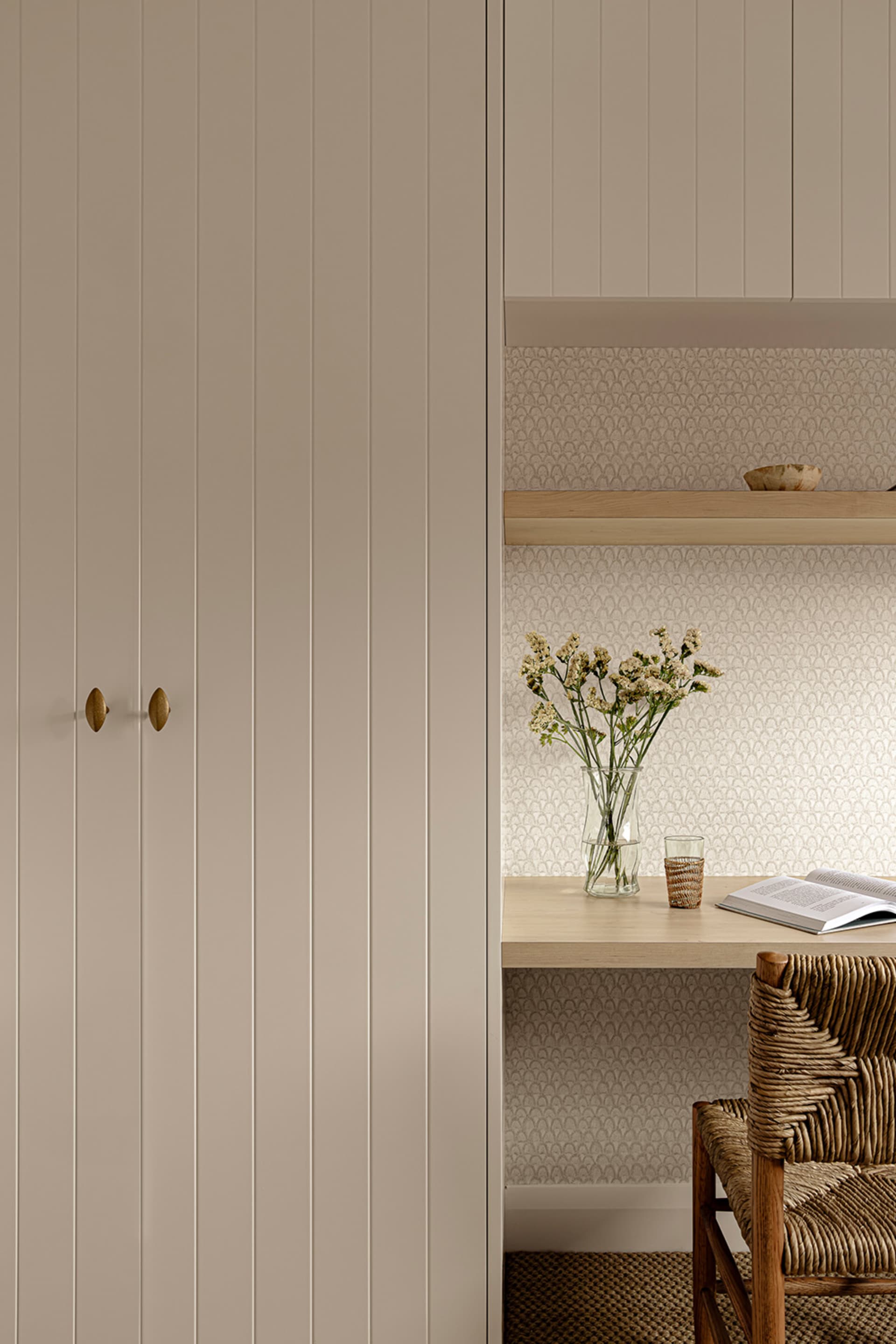 A minimalist home office space featuring wooden furniture and textiles.