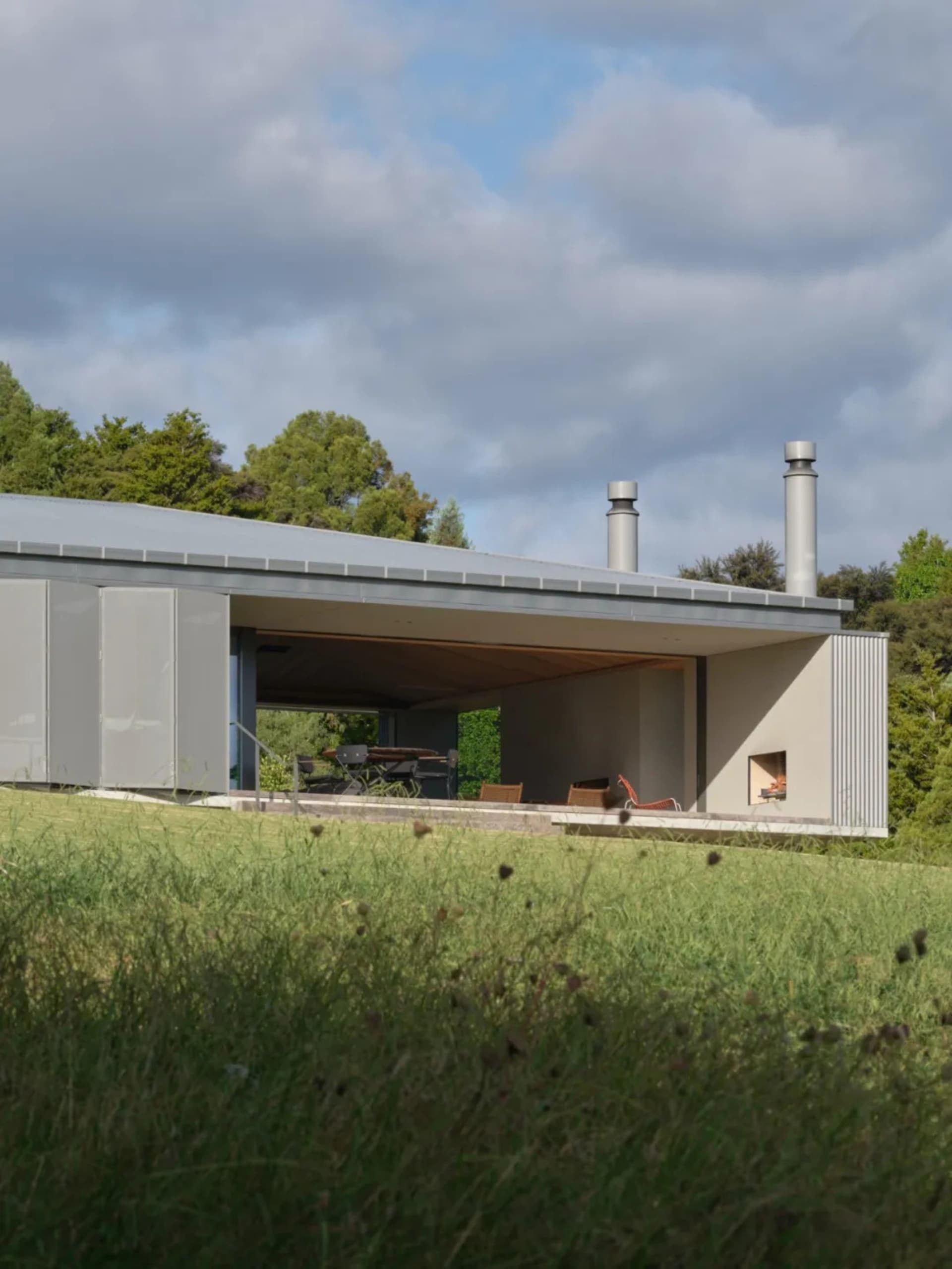 A modern residential building featuring metal, glass, concrete, and wood materials.
