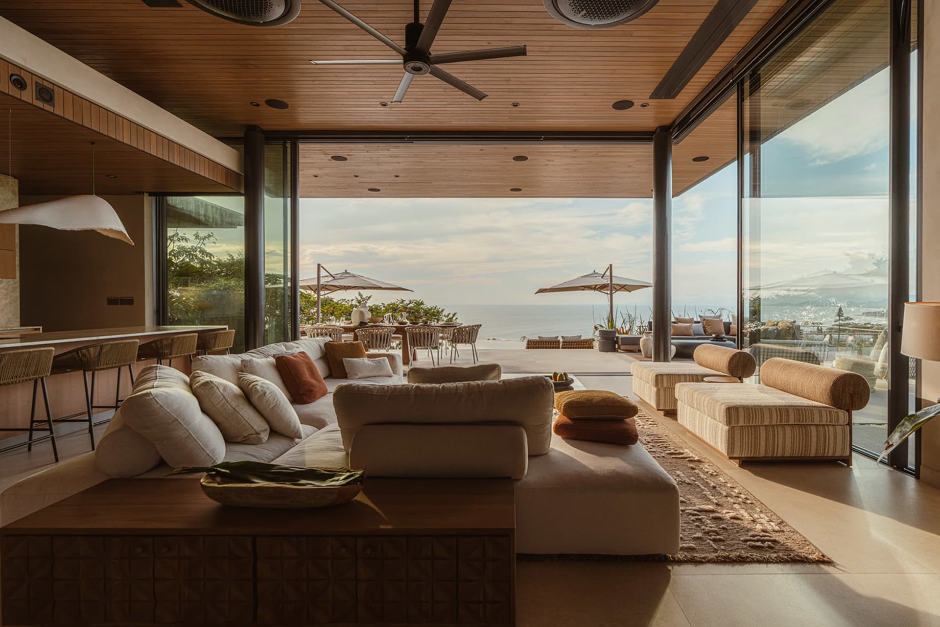 Modern, minimalist living room featuring soft furnishings, open-plan design, and stunning ocean views.