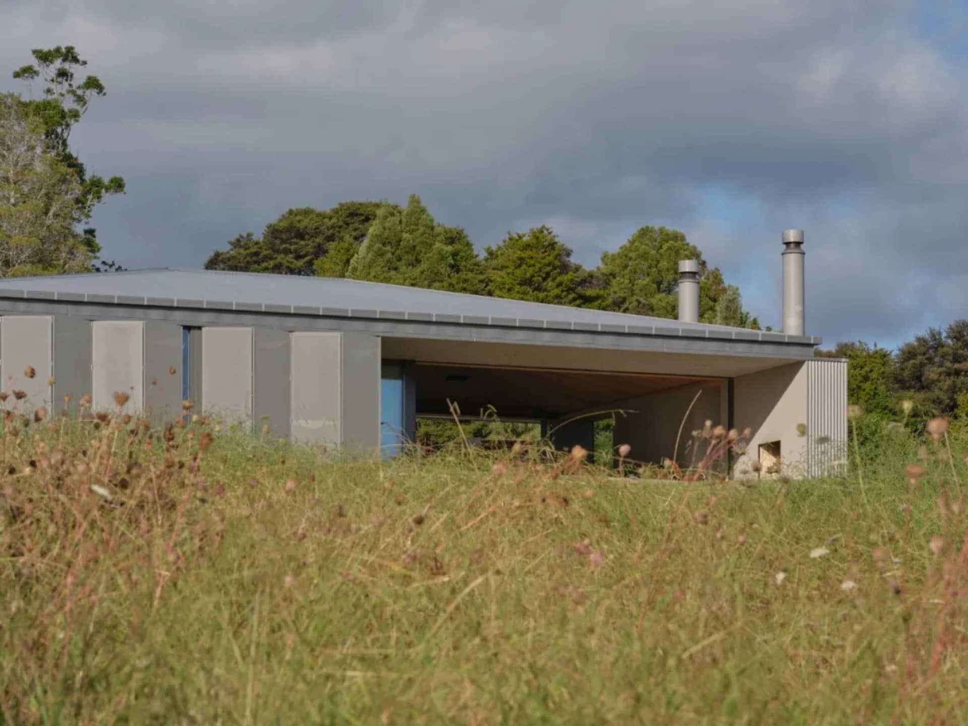 A modern residential exterior with metallic cladding and glass elements.