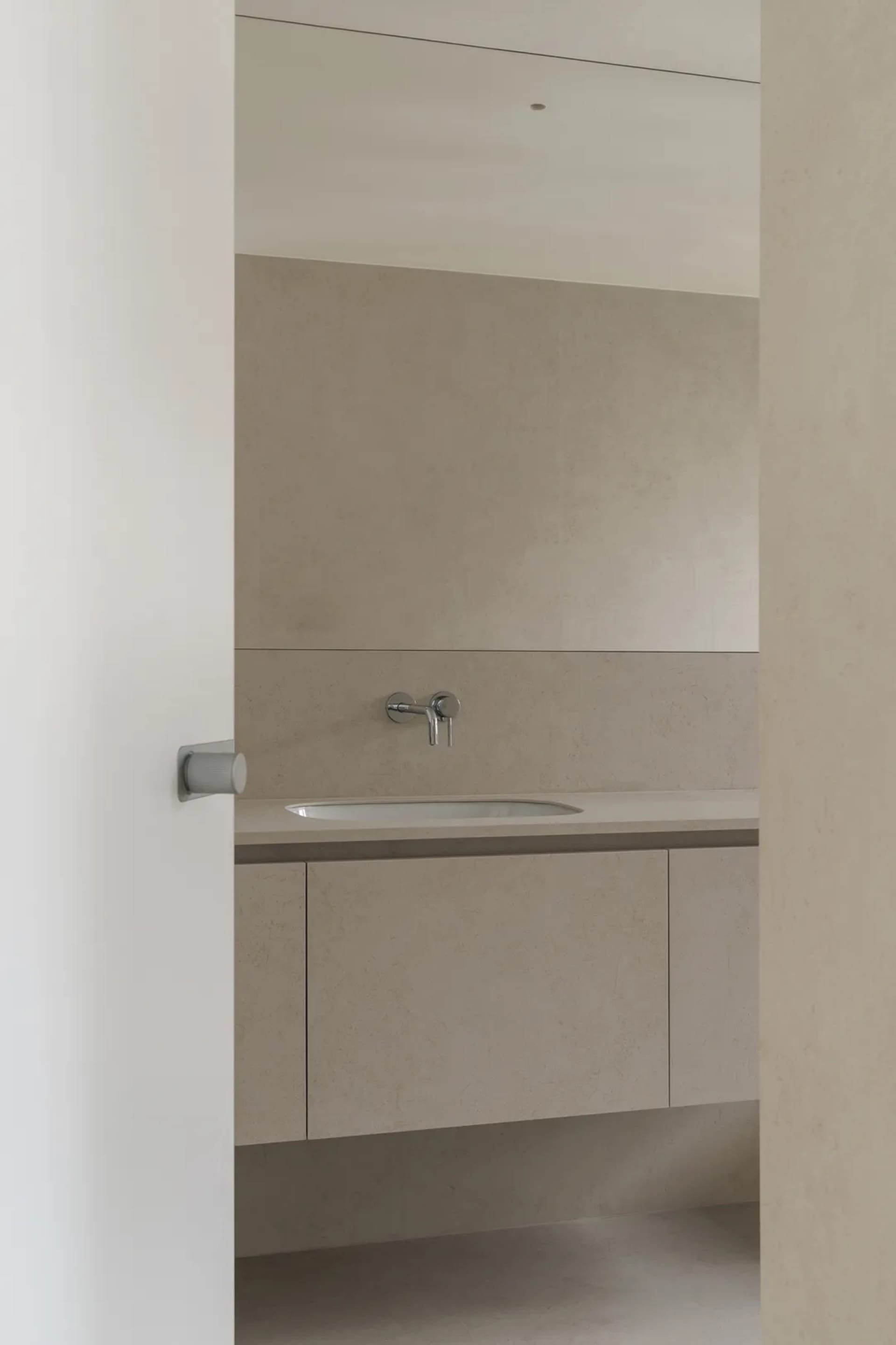 Modern minimalist bathroom with a concrete countertop and sink, no visible clutter or decorations.