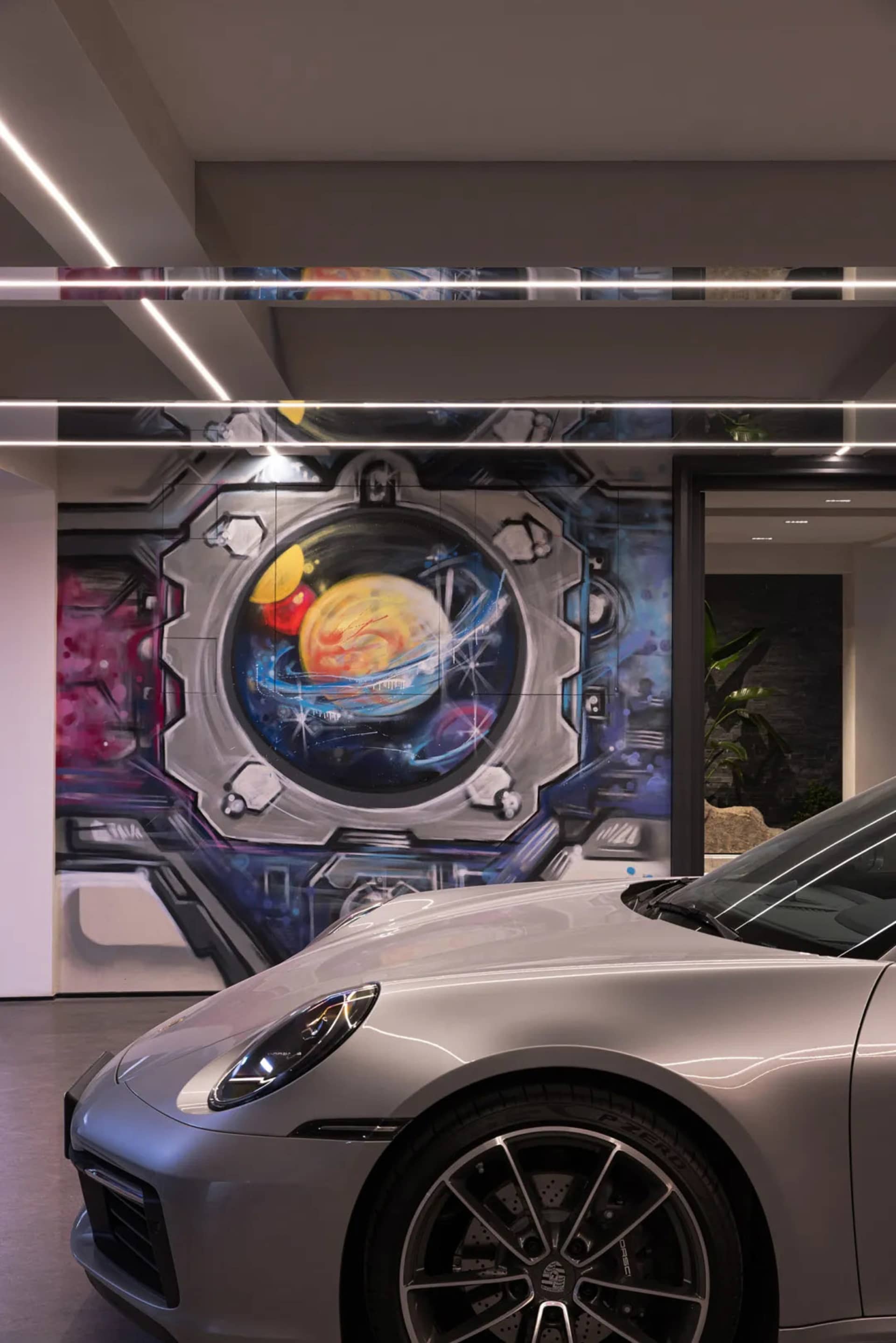 A futuristic metallic garage with a space-themed mural on the wall.