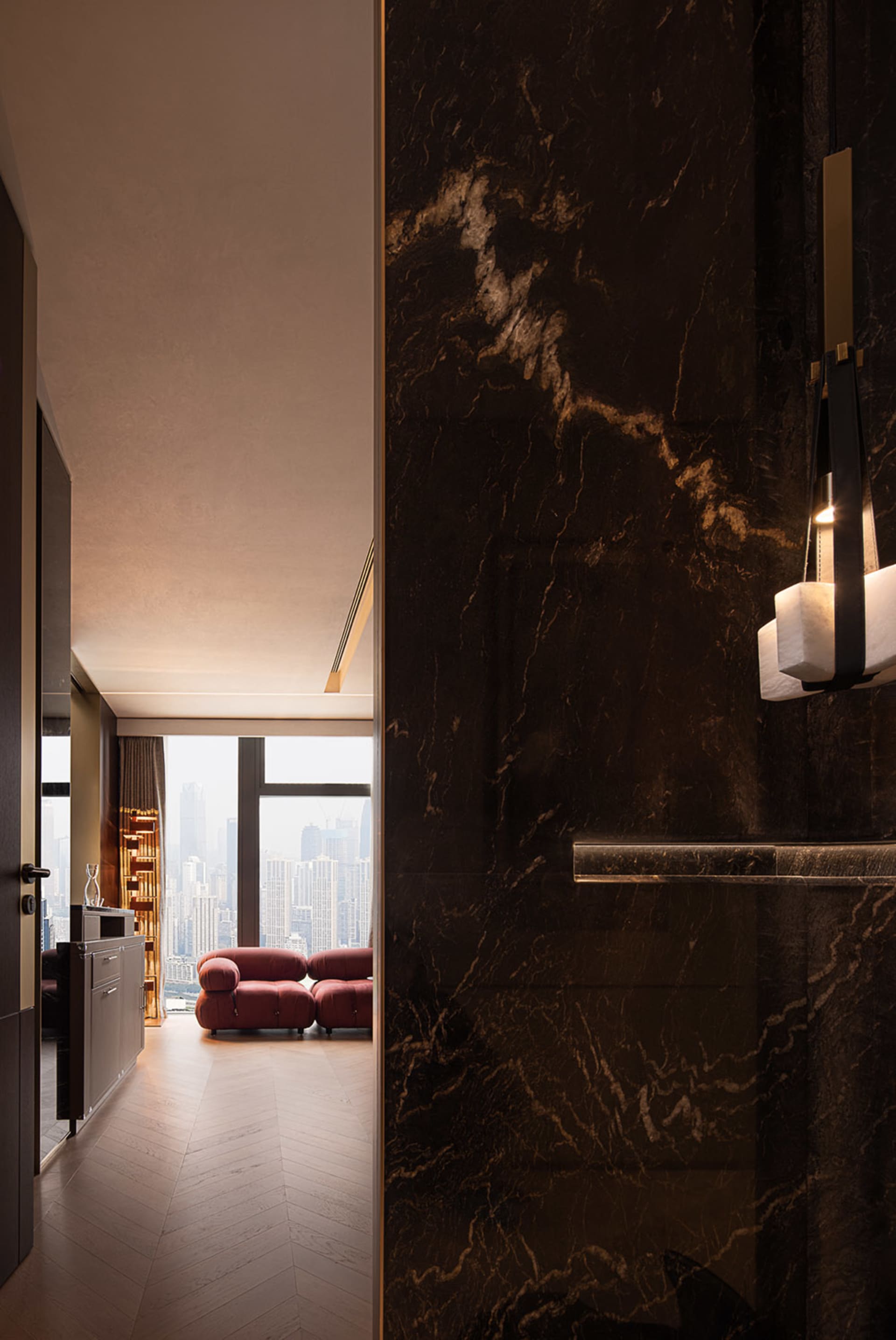 Contemporary condo suite featuring modern furniture and marble walls.
