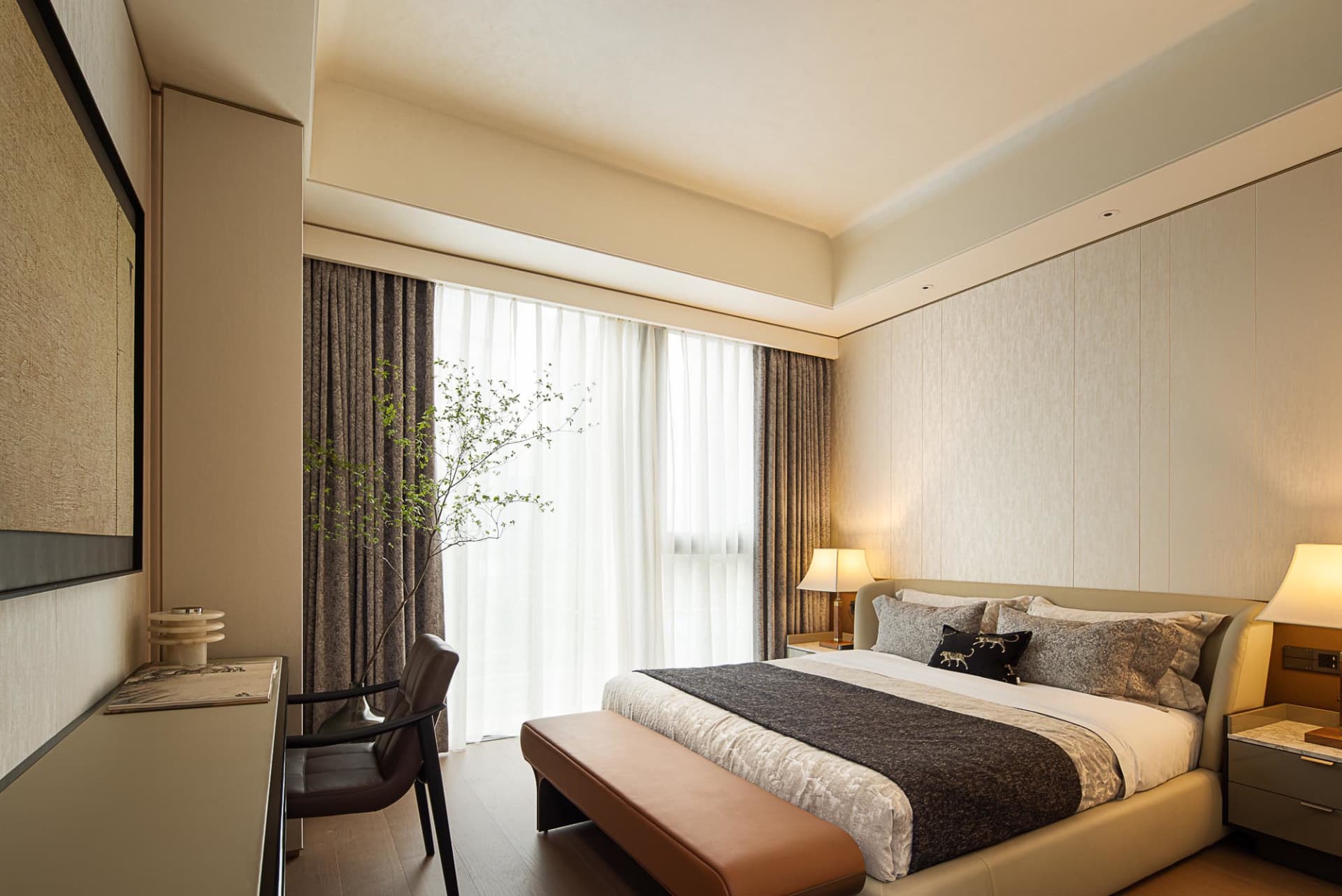 A modern bedroom with fabric finishes and a large window.