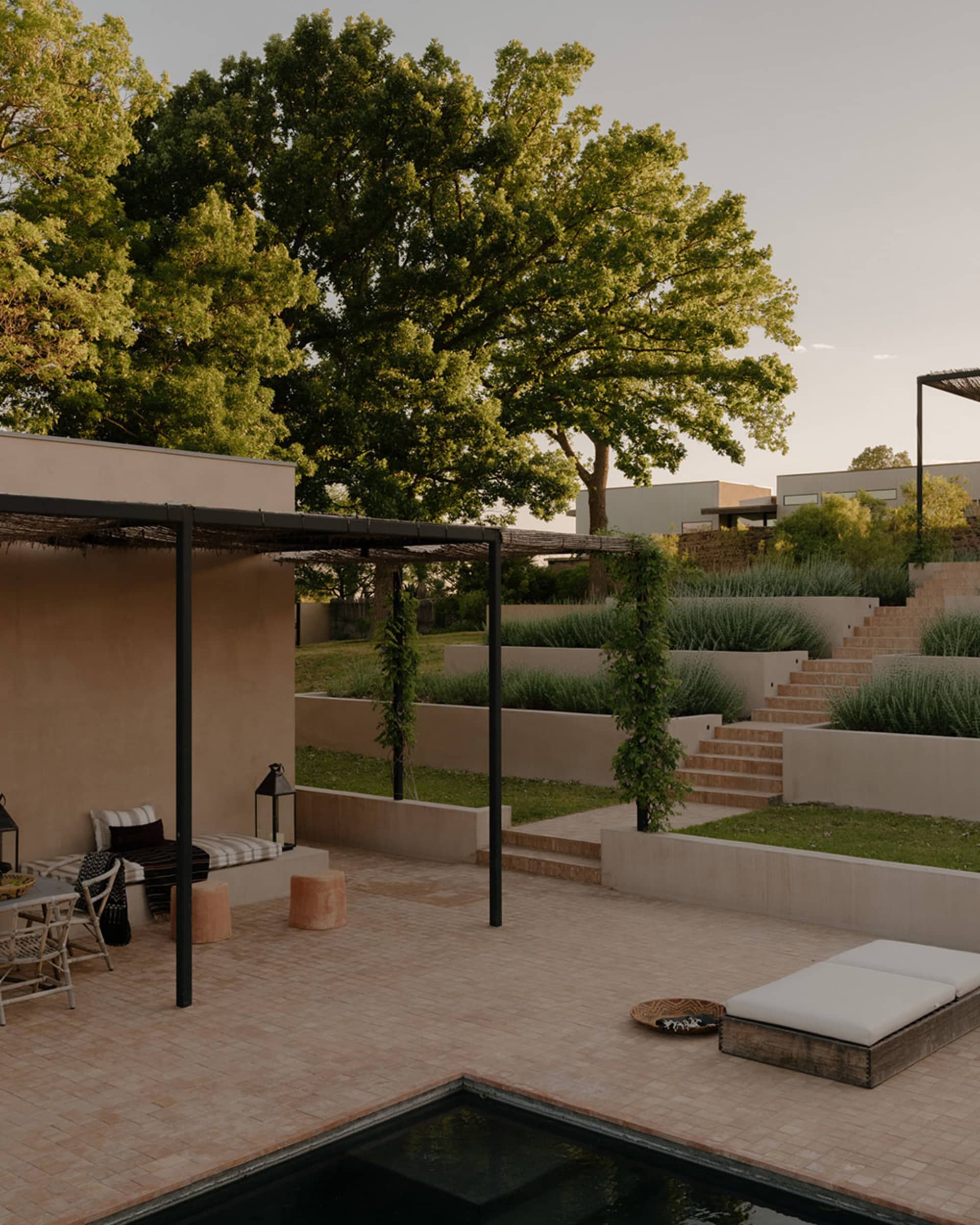 Modern residential outdoor space featuring concrete, gravel, stone, and metal elements.