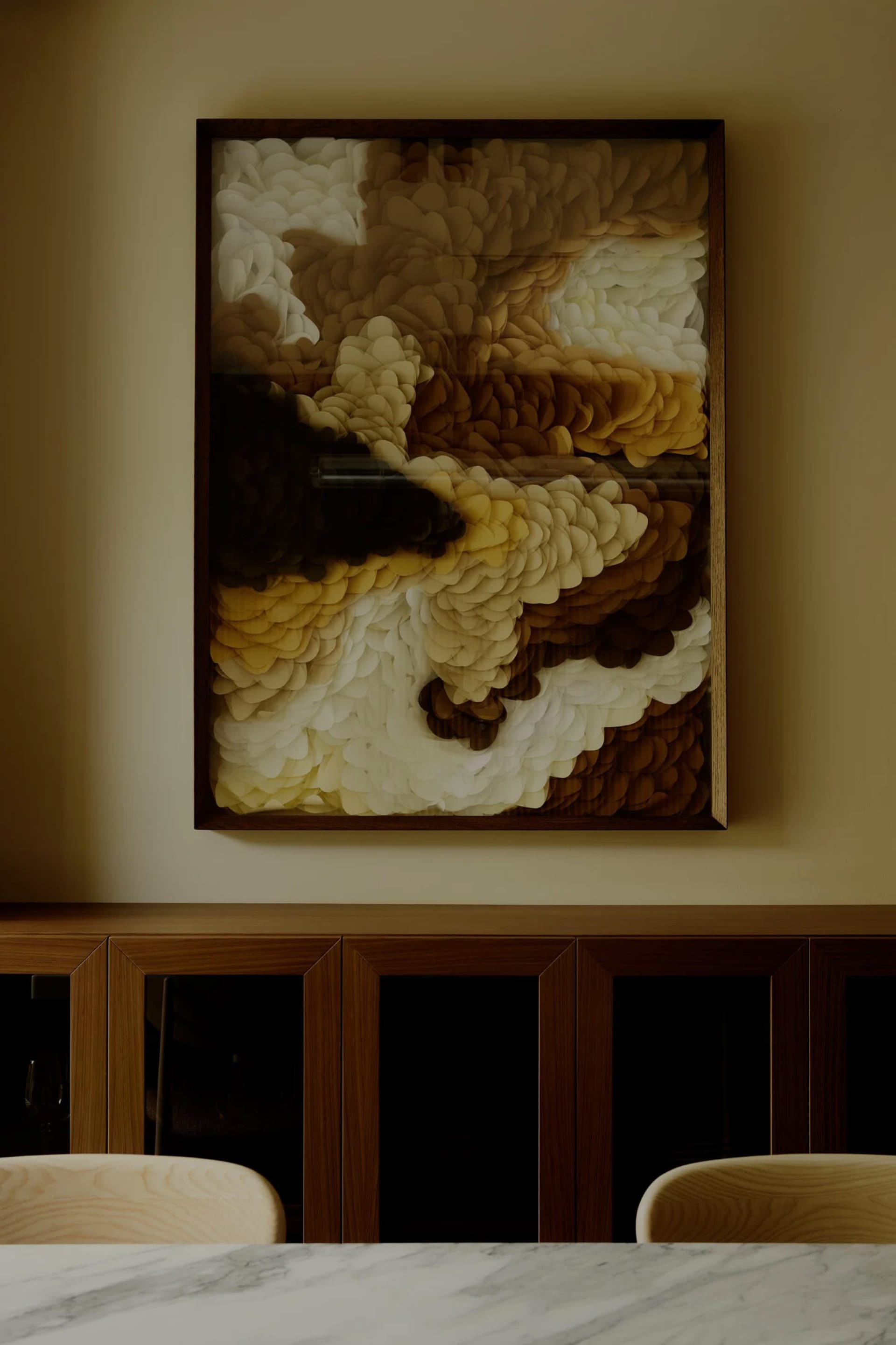 A piece of abstract art made from paper-cutting techniques, featuring layers of brown, white, and yellow shapes.