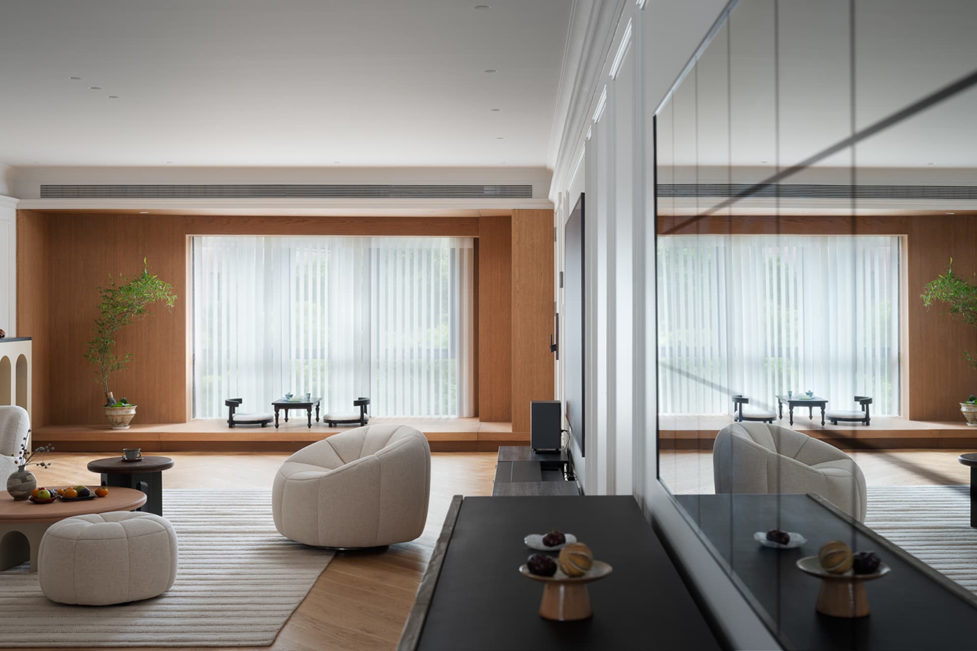 A modern living room featuring wooden coffee tables, glass vases, and contemporary furniture with soft upholstery.