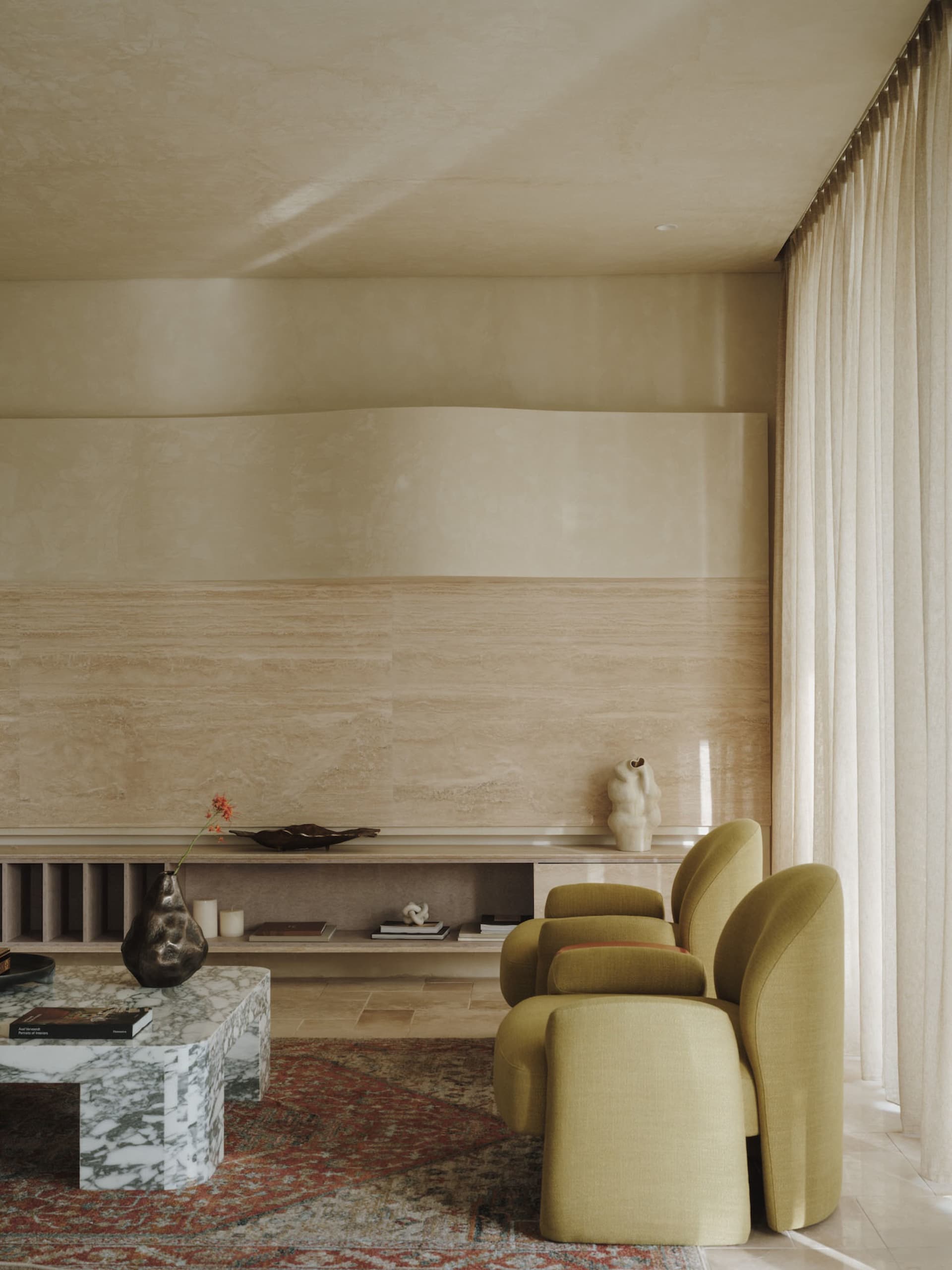 A living room with minimalist design, featuring marble accents, fabric furniture, glass elements, and wooden finishes.