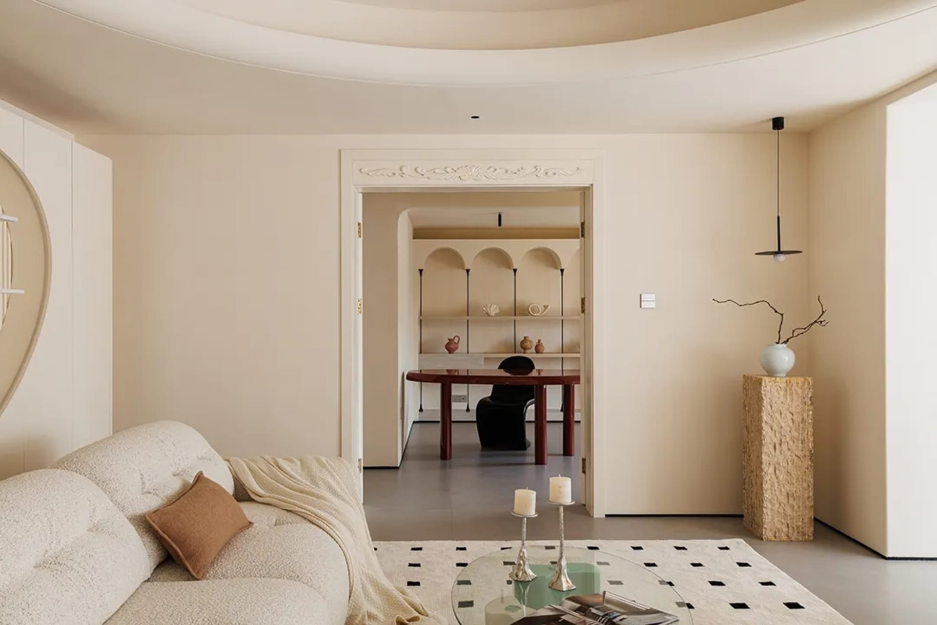 A modern living room with a neutral color palette and a glass coffee table.