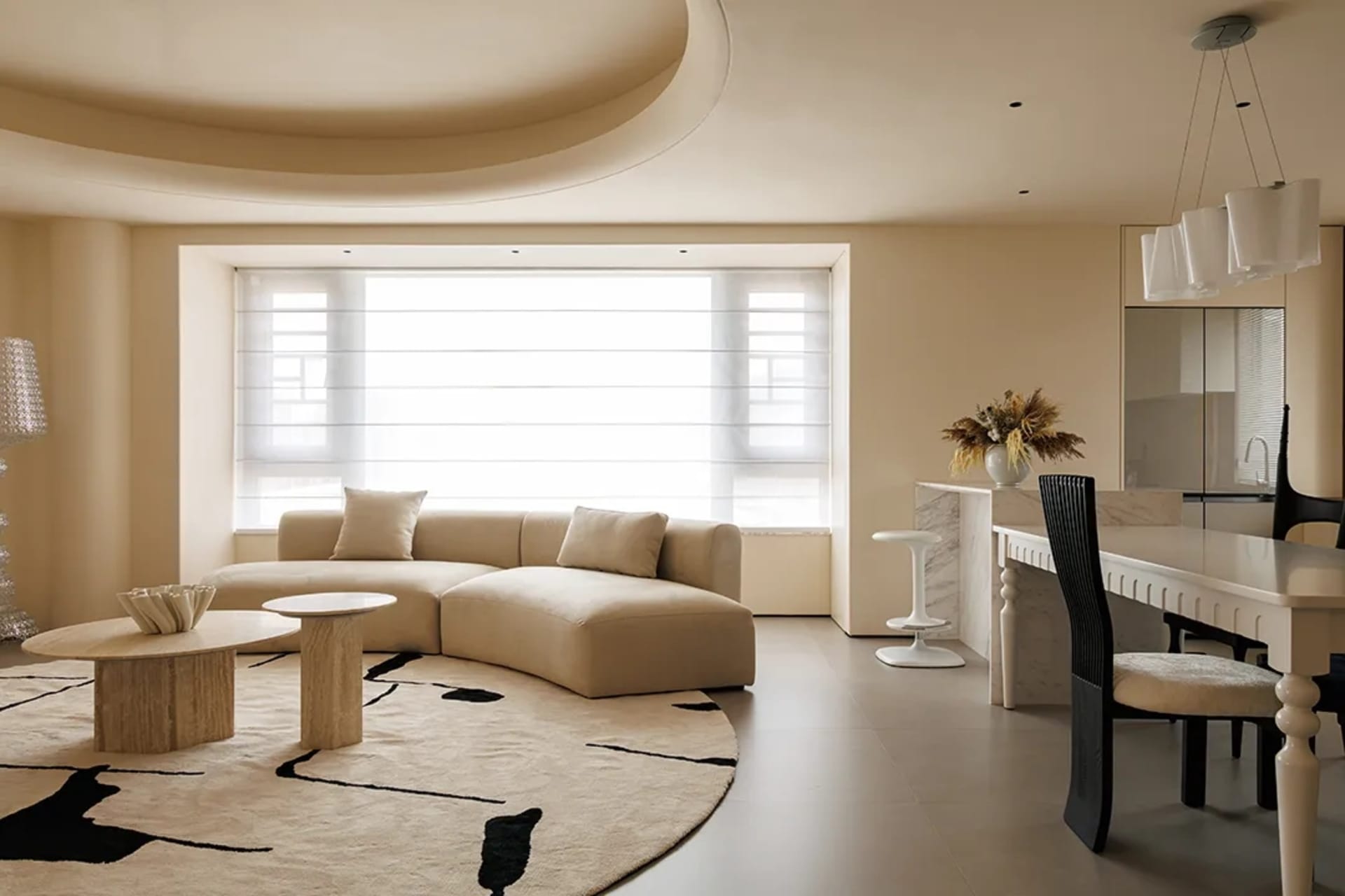 Modern living room with neutral tones and a curved sofa.