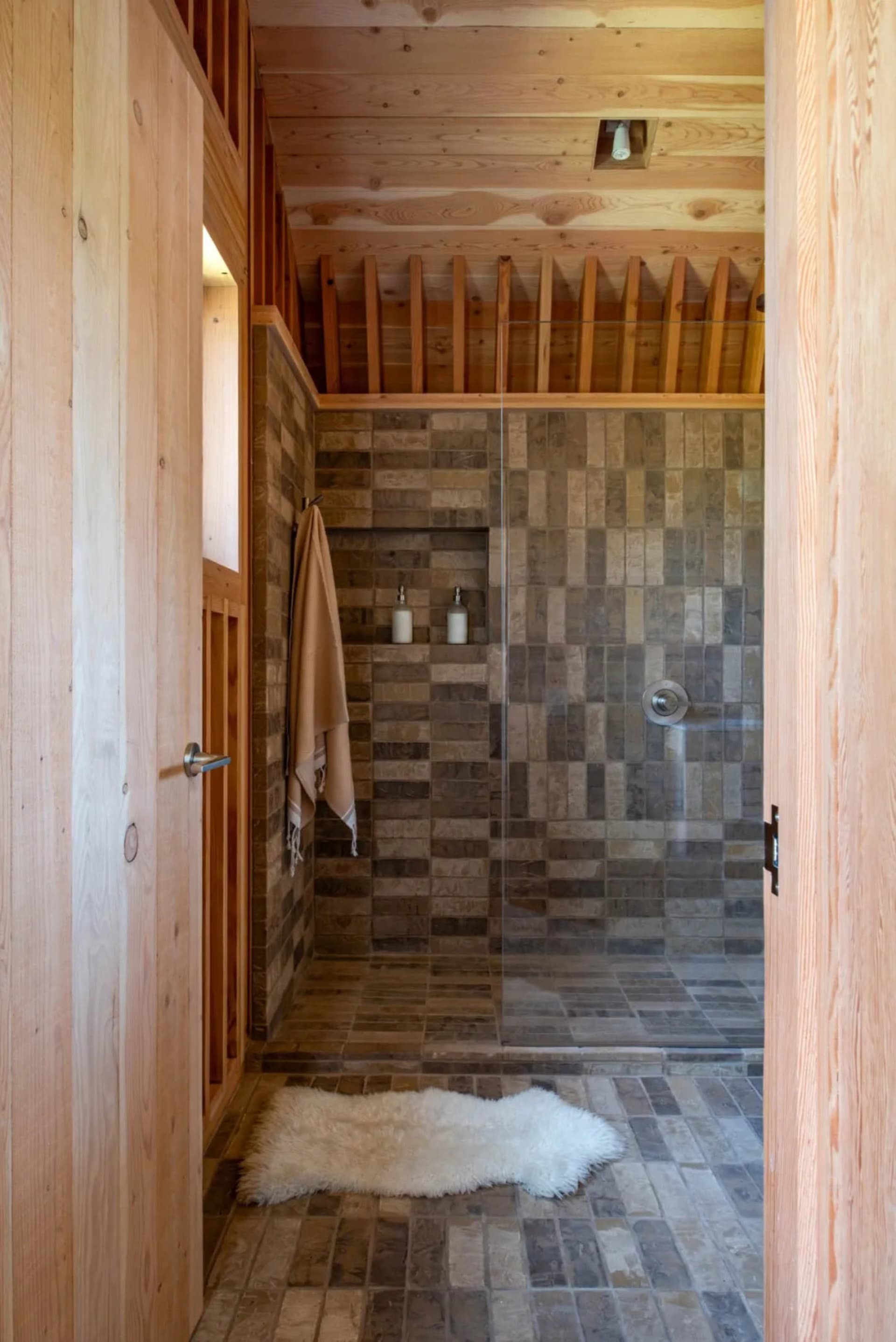 Modern bathroom featuring a tiled shower area with a glass partition.