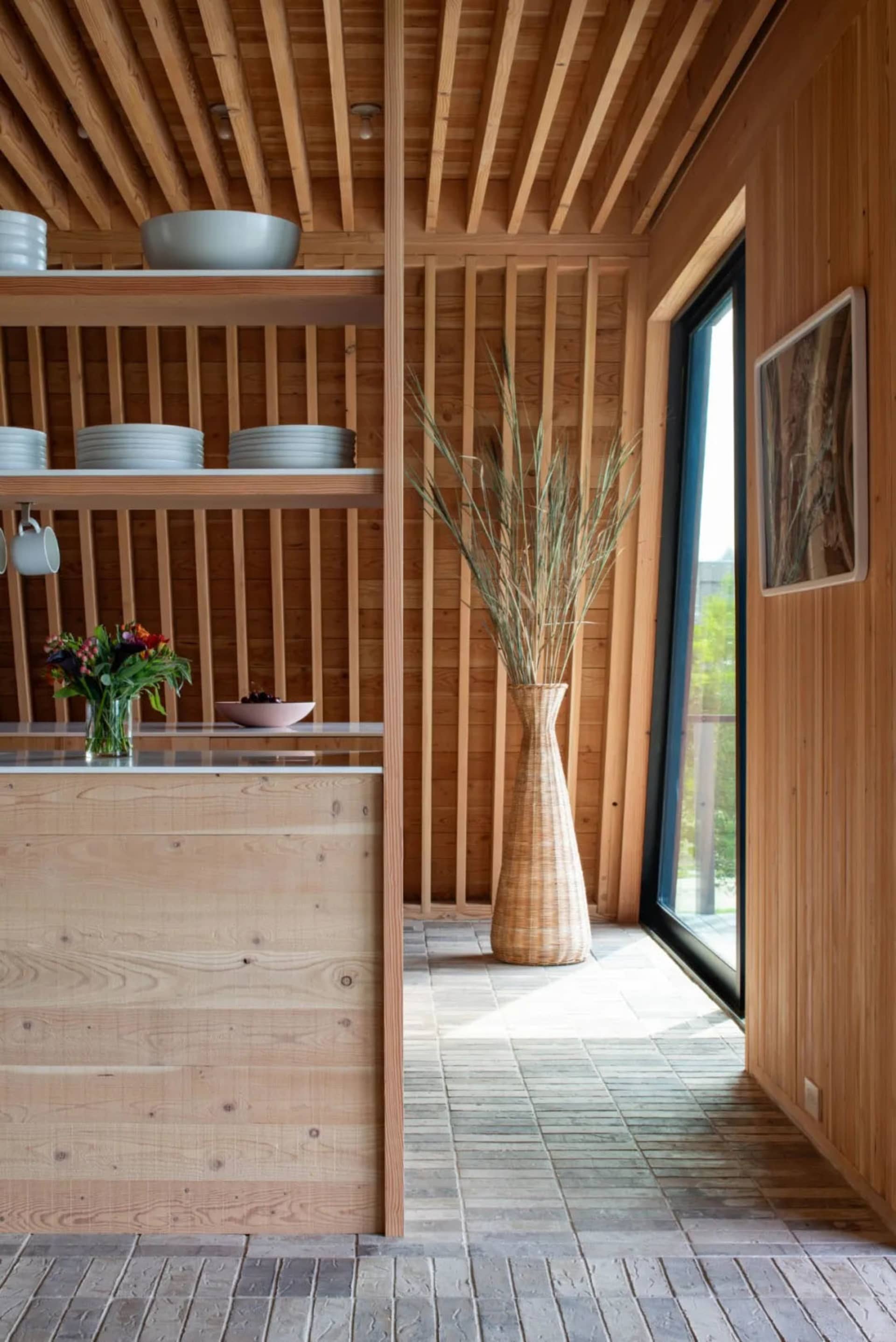 Modern minimalistic kitchen with wooden surfaces and versatile shelves.