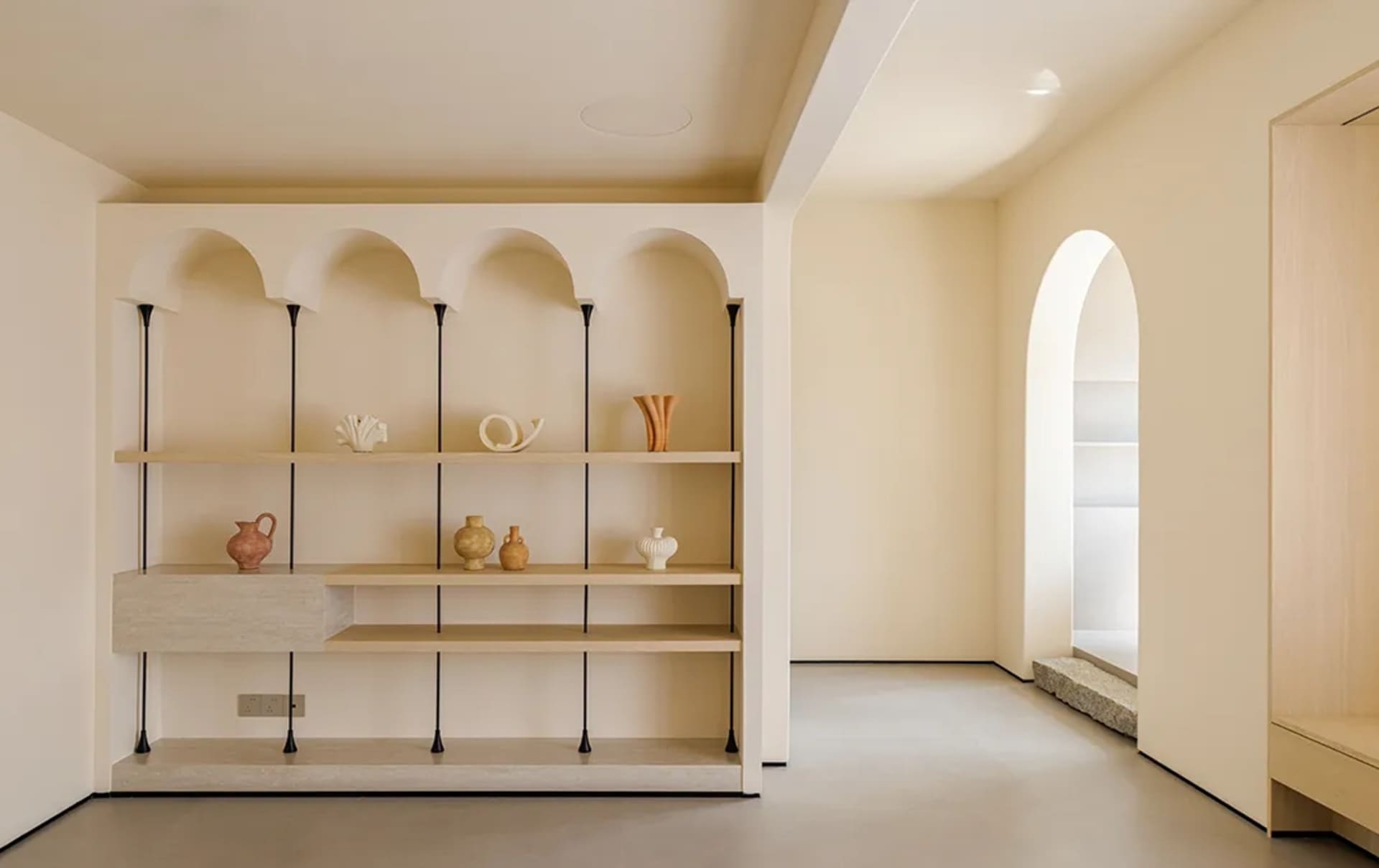 A modern shelf display featuring objects on walnut and concrete shelves with black accents.